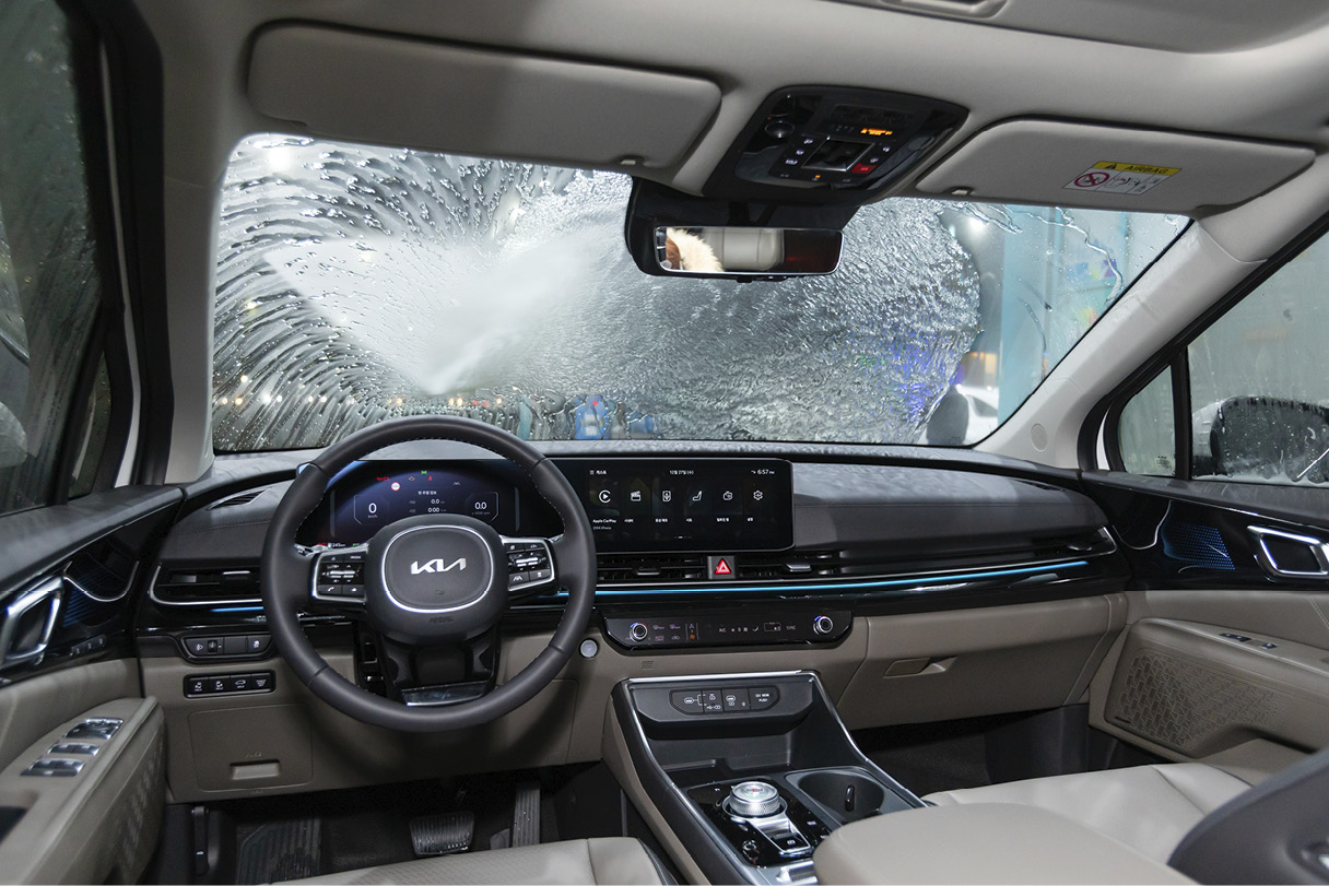 An indoor view of high-pressure water being sprayed on the windshield.
