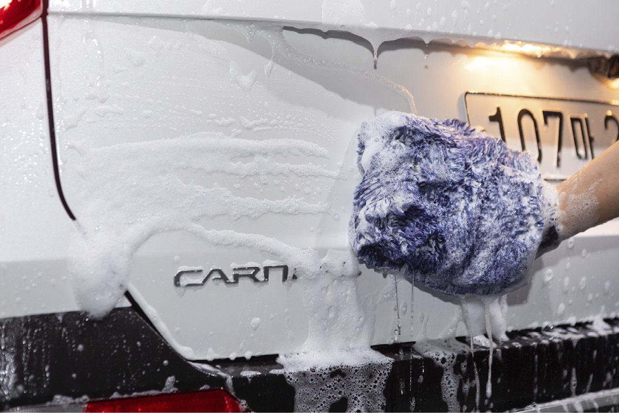 A car wash is in progress using a wash mitt.