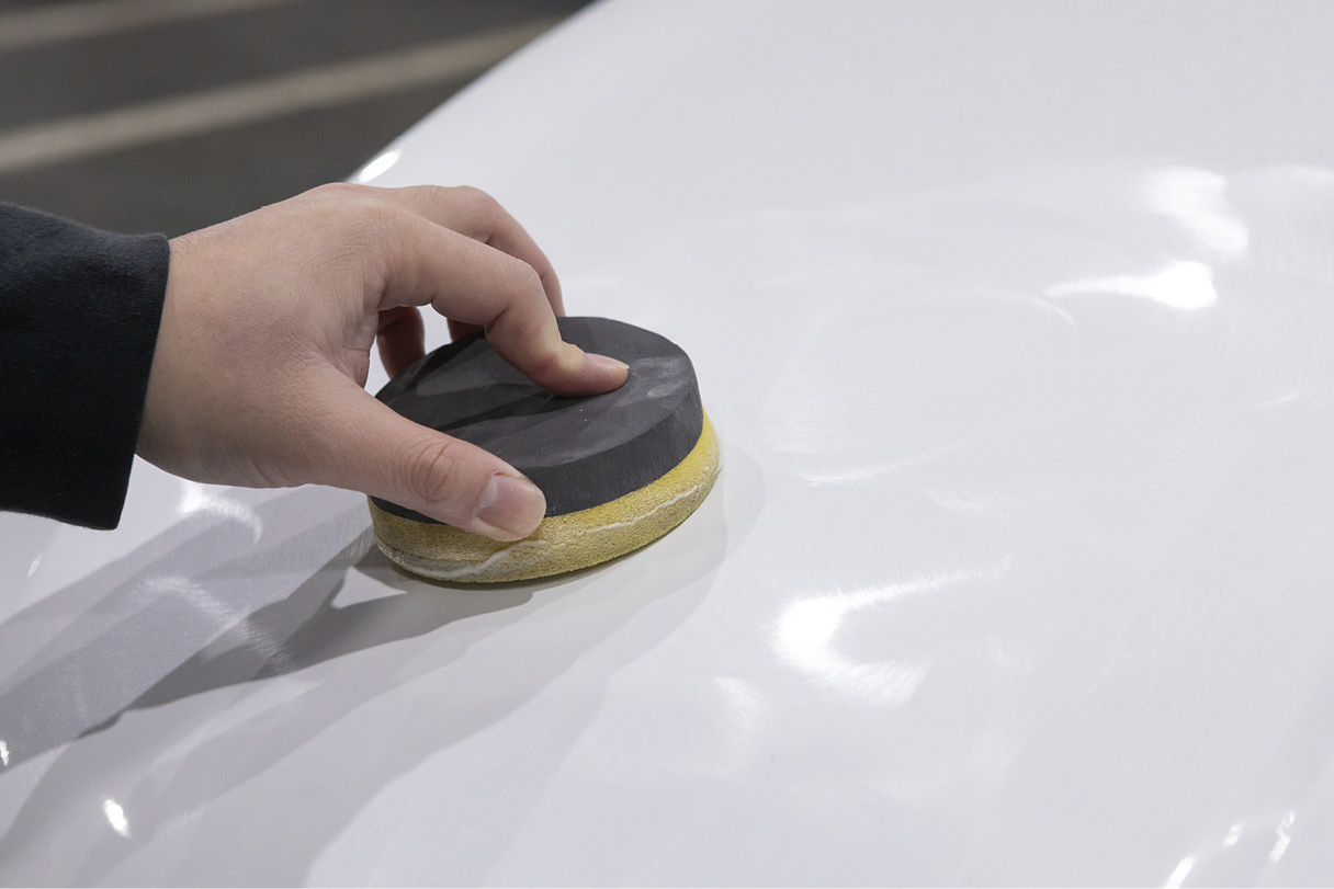 A person is applying solid wax for coating