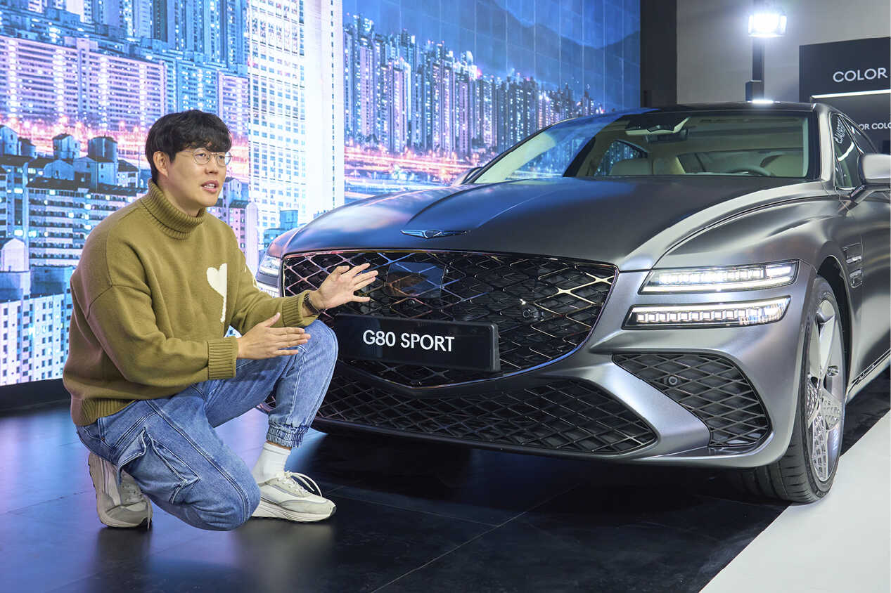 G80 앞에서 부분변경 모델의 달라진 점에 대하여 설명하는 전시 기획 담당자