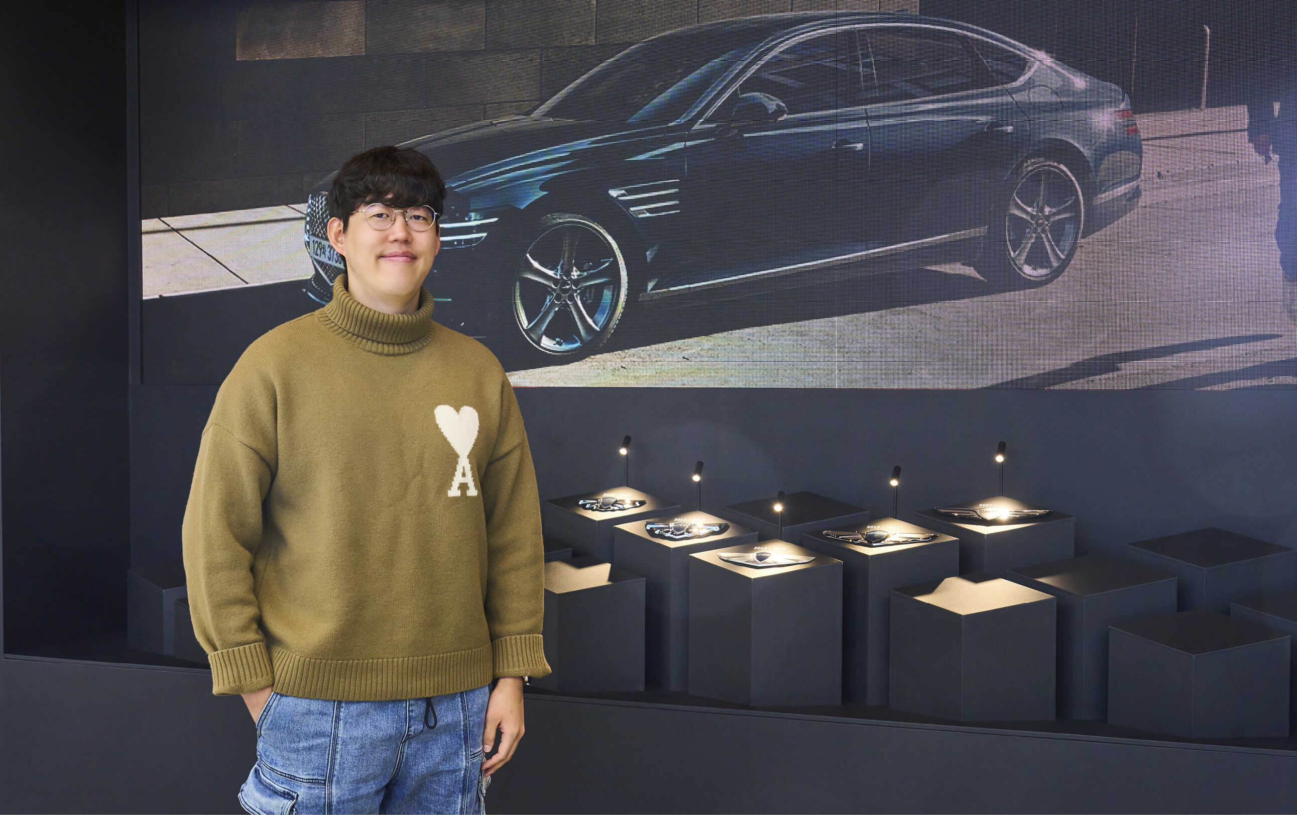 G80 전시를 기획한 제네시스 담당자가 엠블럼 전시월 앞에 서있는 모습