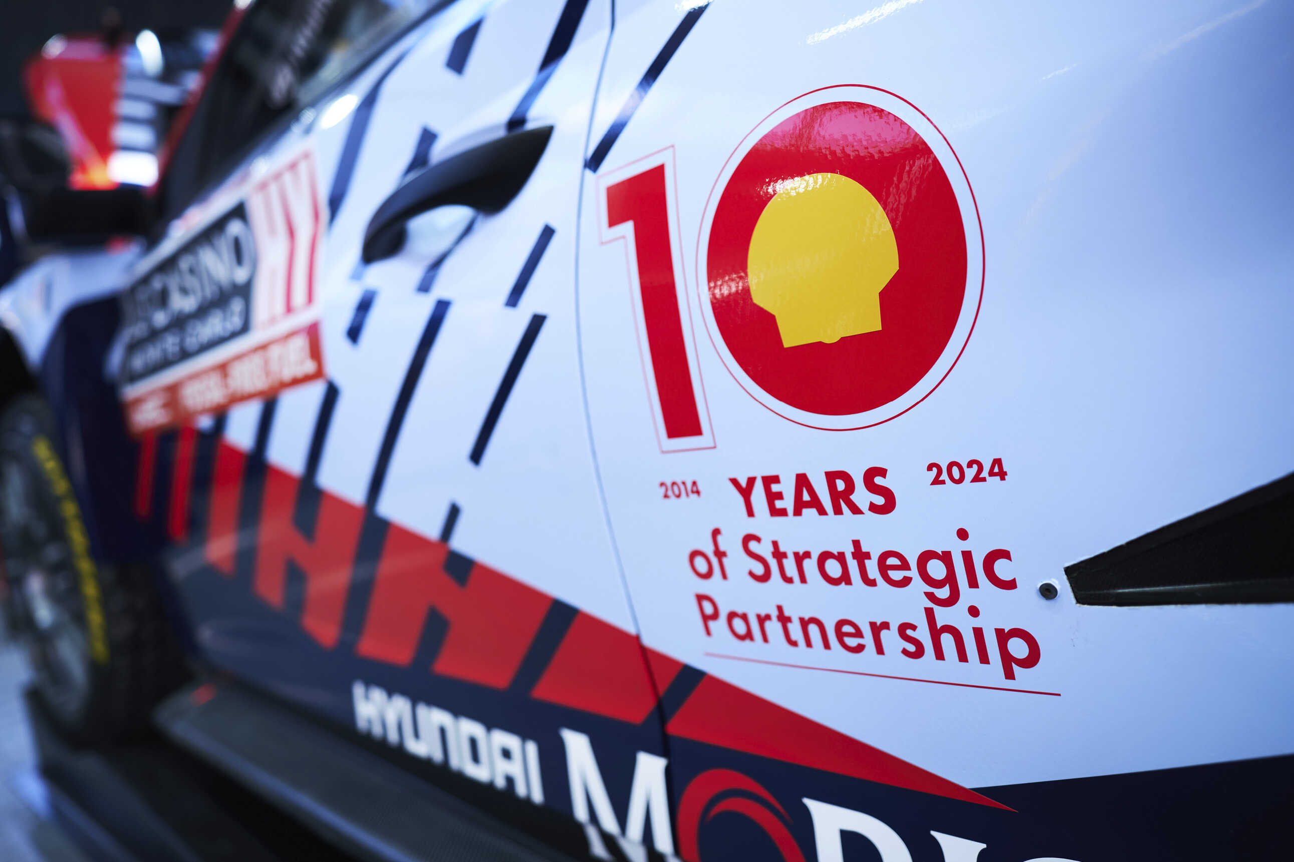 A sticker commemorating the 10th anniversary of its return to the WRC is attached to the side of the Hyundai rally car.