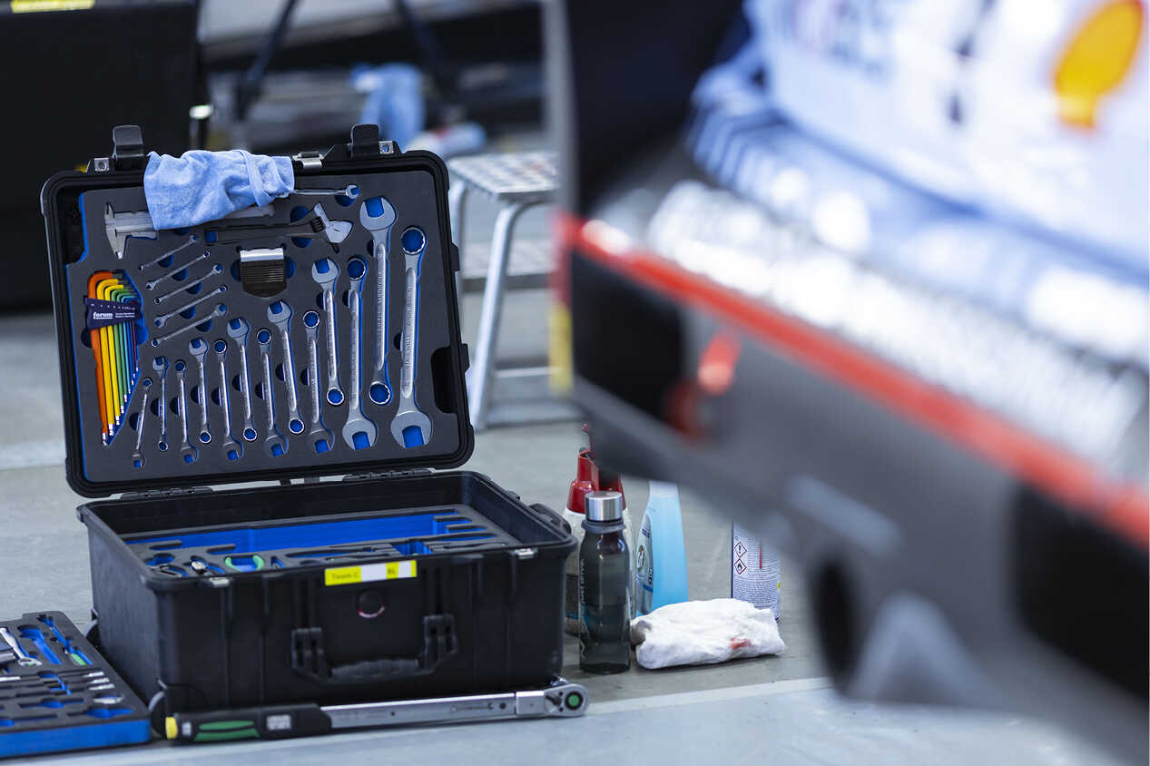 A set of various tools are displayed over the rear bumper of a Hyundai rally car.