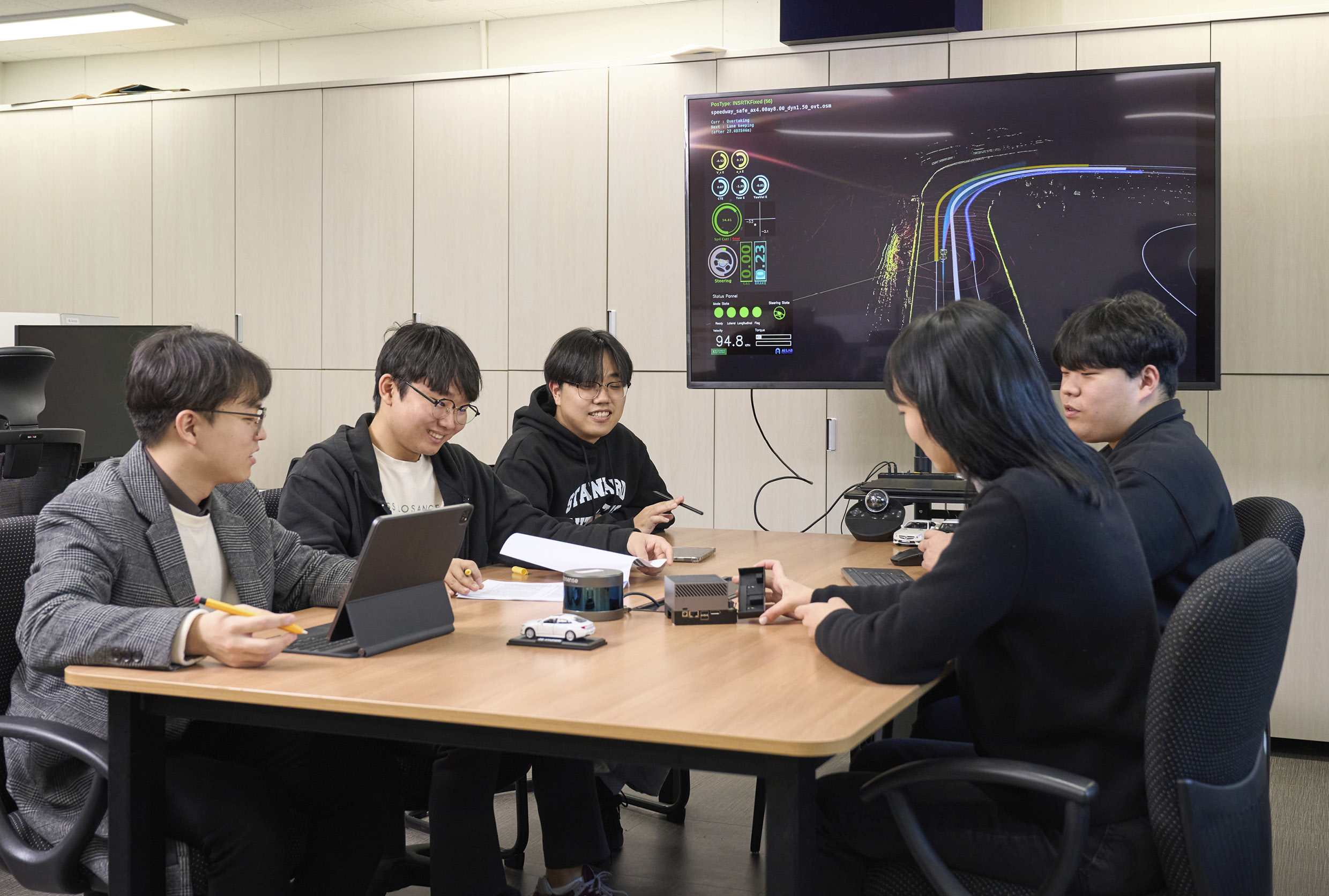 AutoKU-R 팀이 회의실에 모여 이야기를 나누고 있다