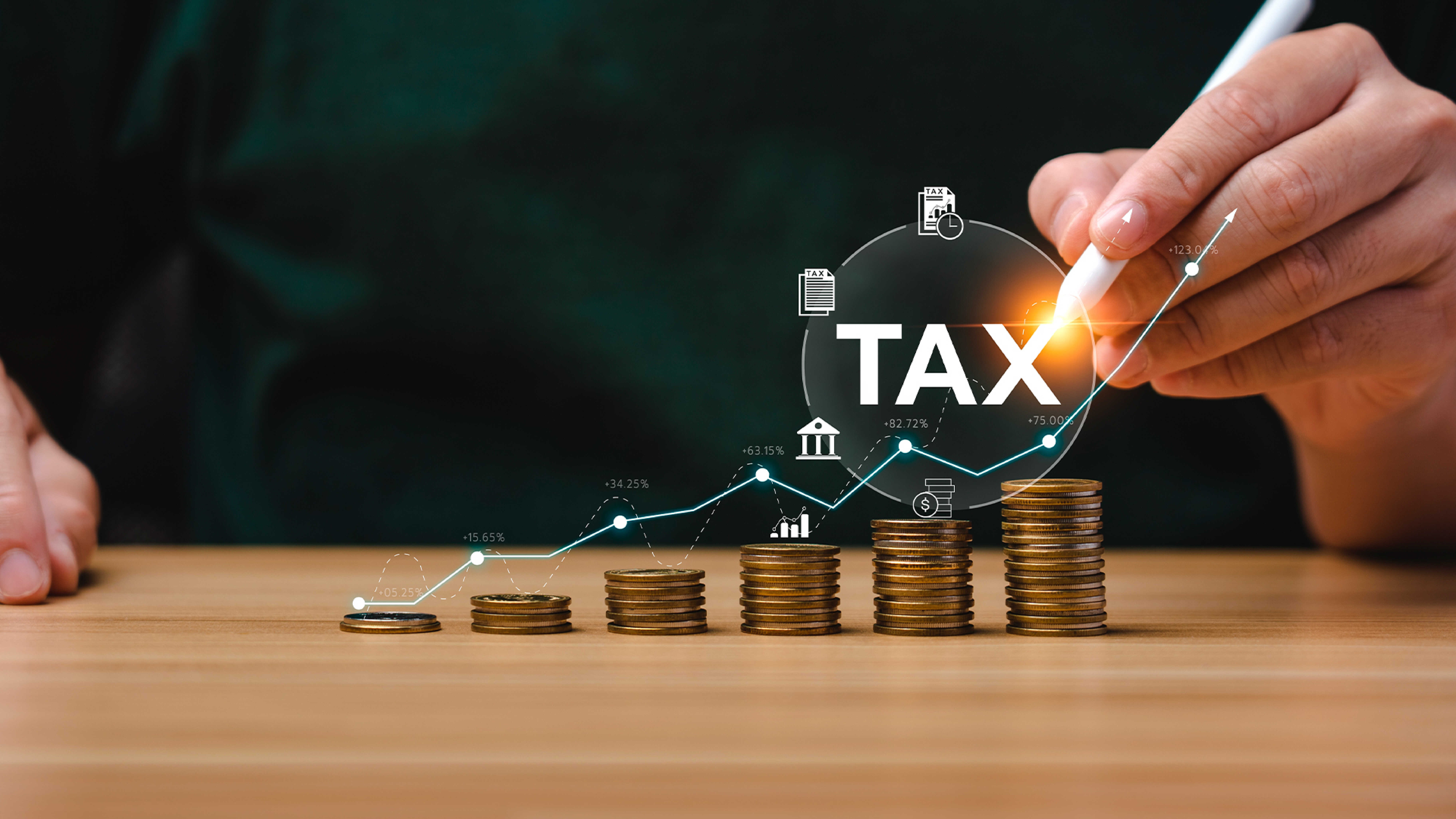 층층이 쌓여 있는 동전과 이를 연필로 가리키는 손가락의 모습