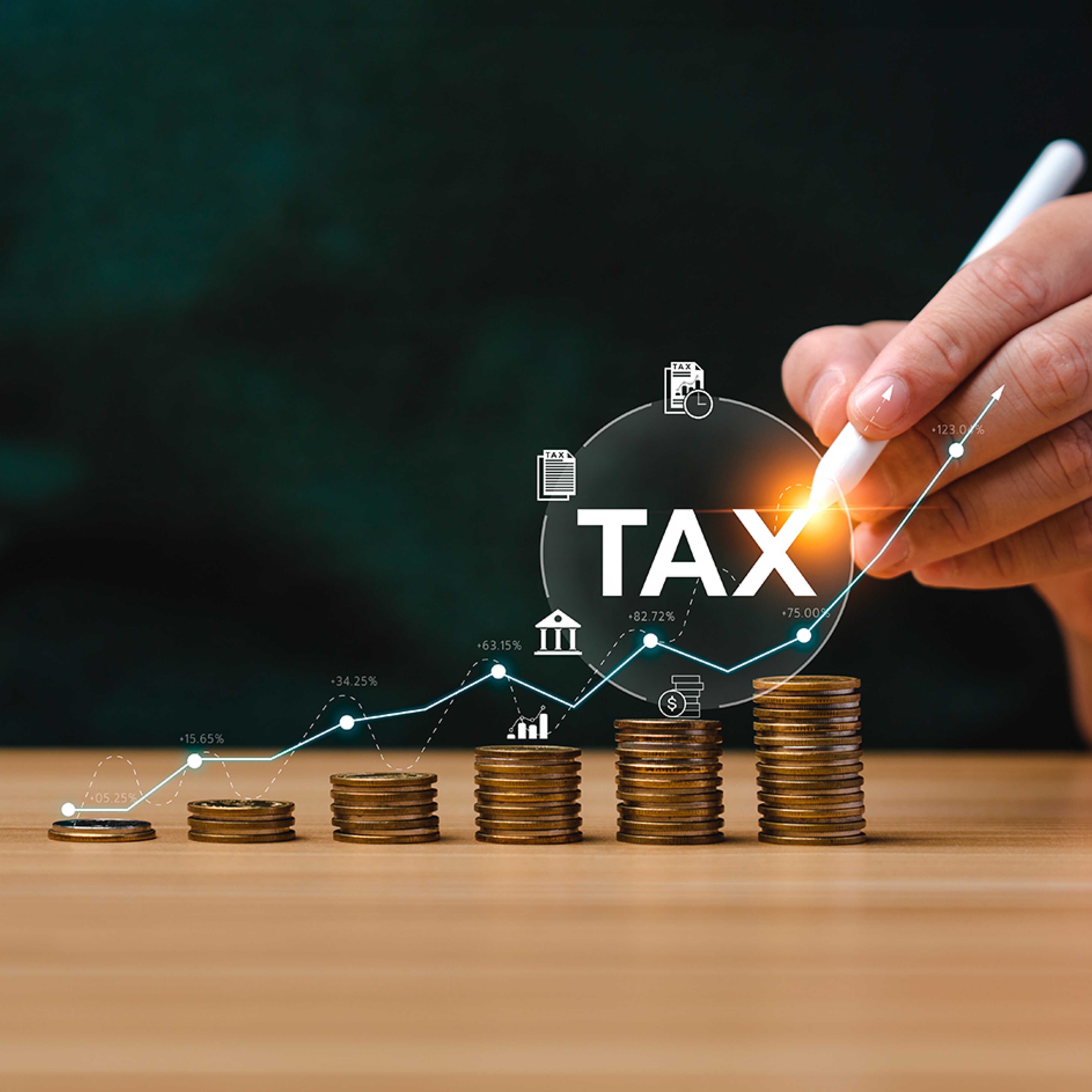 층층이 쌓여 있는 동전과 이를 연필로 가리키는 손가락의 모습