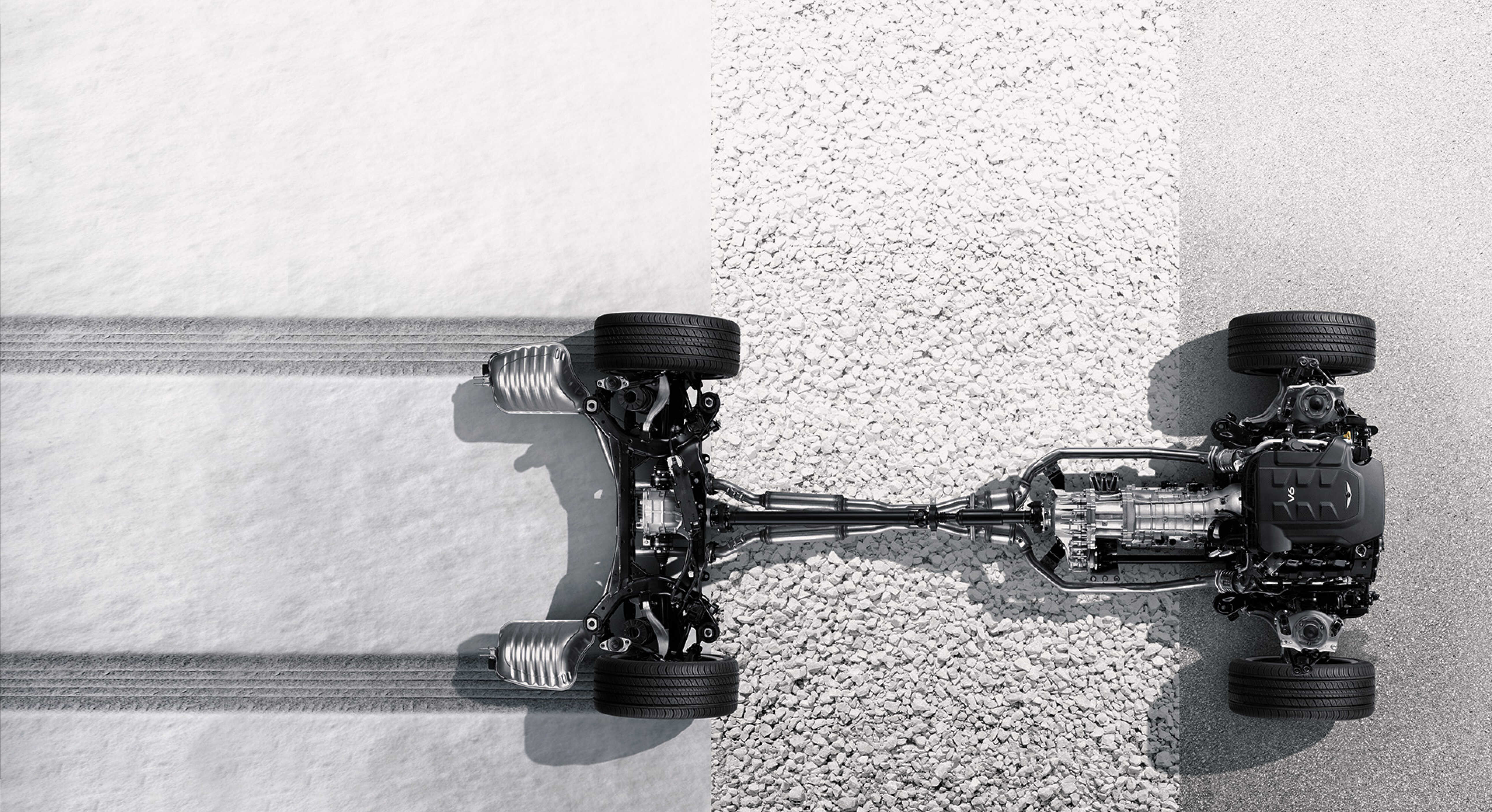 자동차 구동계가 눈, 자갈, 아스팔트 노면에 걸친 것을 정위에서 아래로 내려다 본 모습