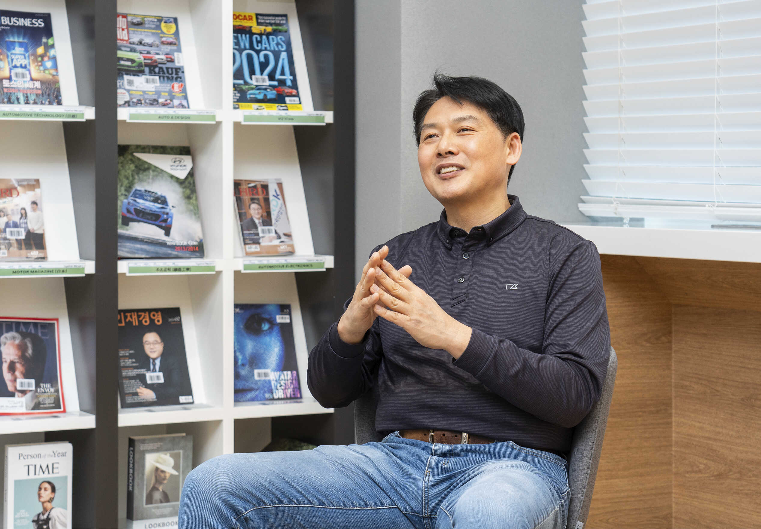 성인 남성이 도서실 의자에 앉아 포즈를 취한 모습