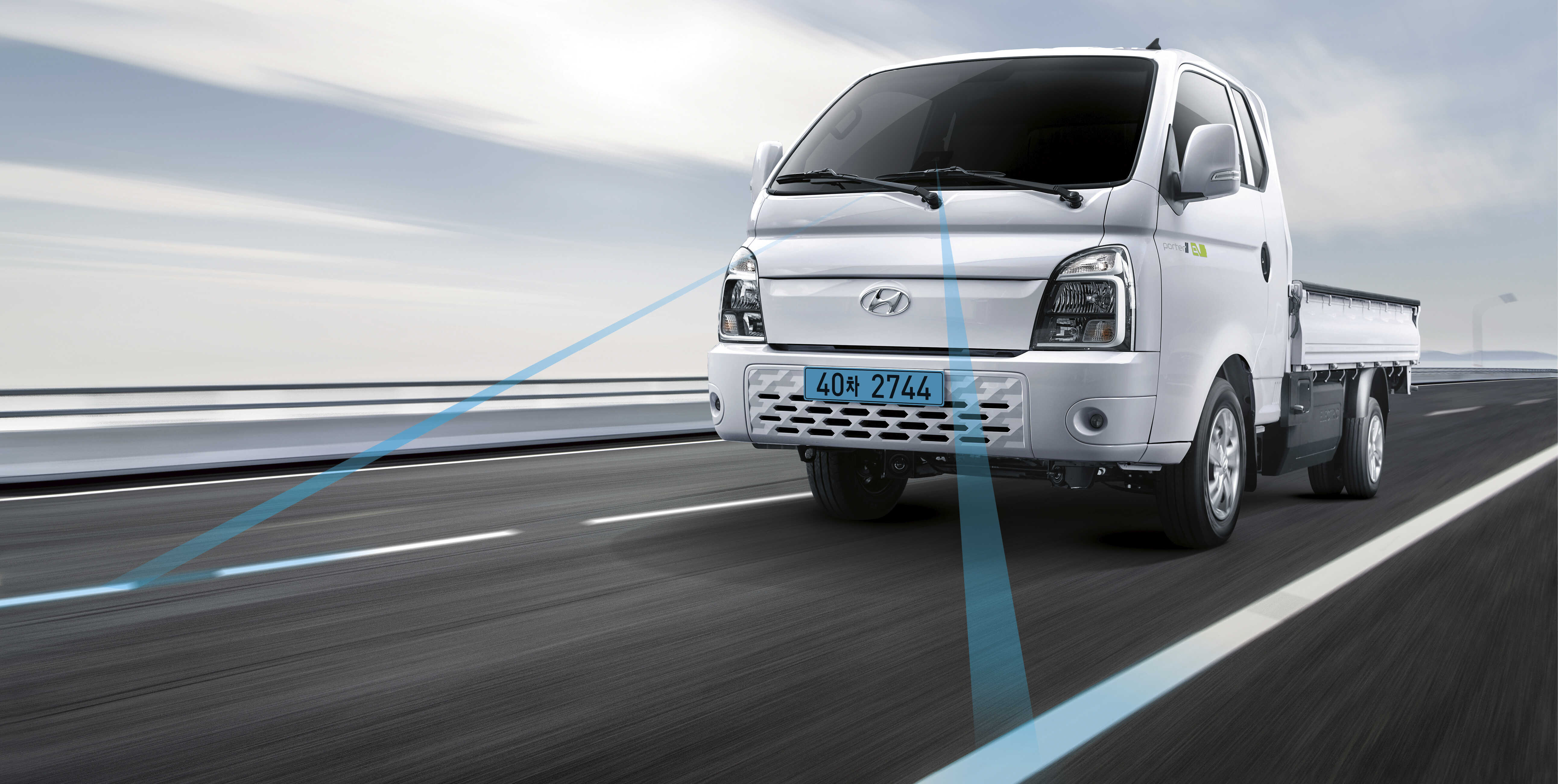 자동차 전용도로를 주행하는 흰색 1톤 포터II의 전측면 모습