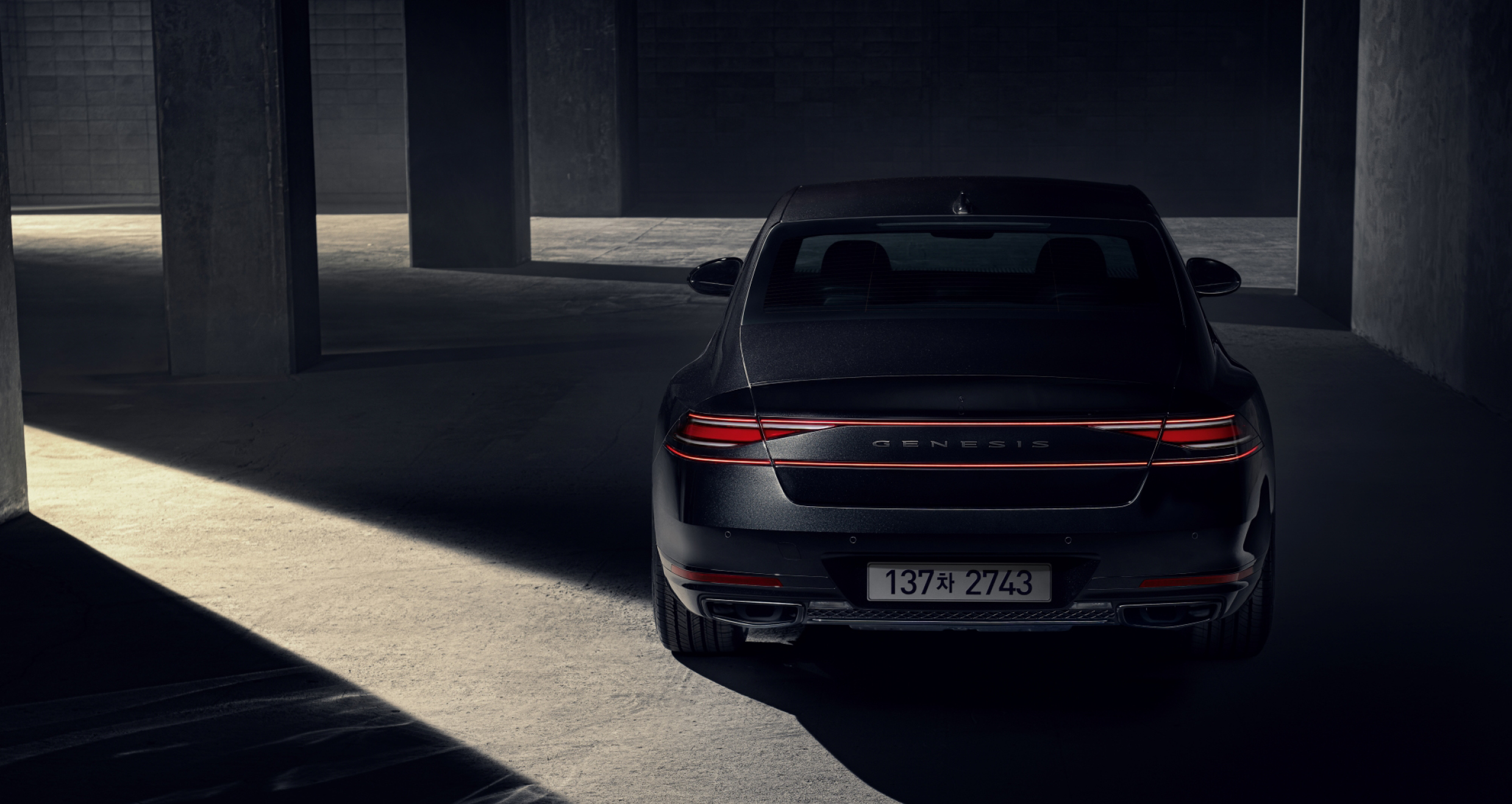 기둥 사이에 서 있는 G90 블랙의 후면