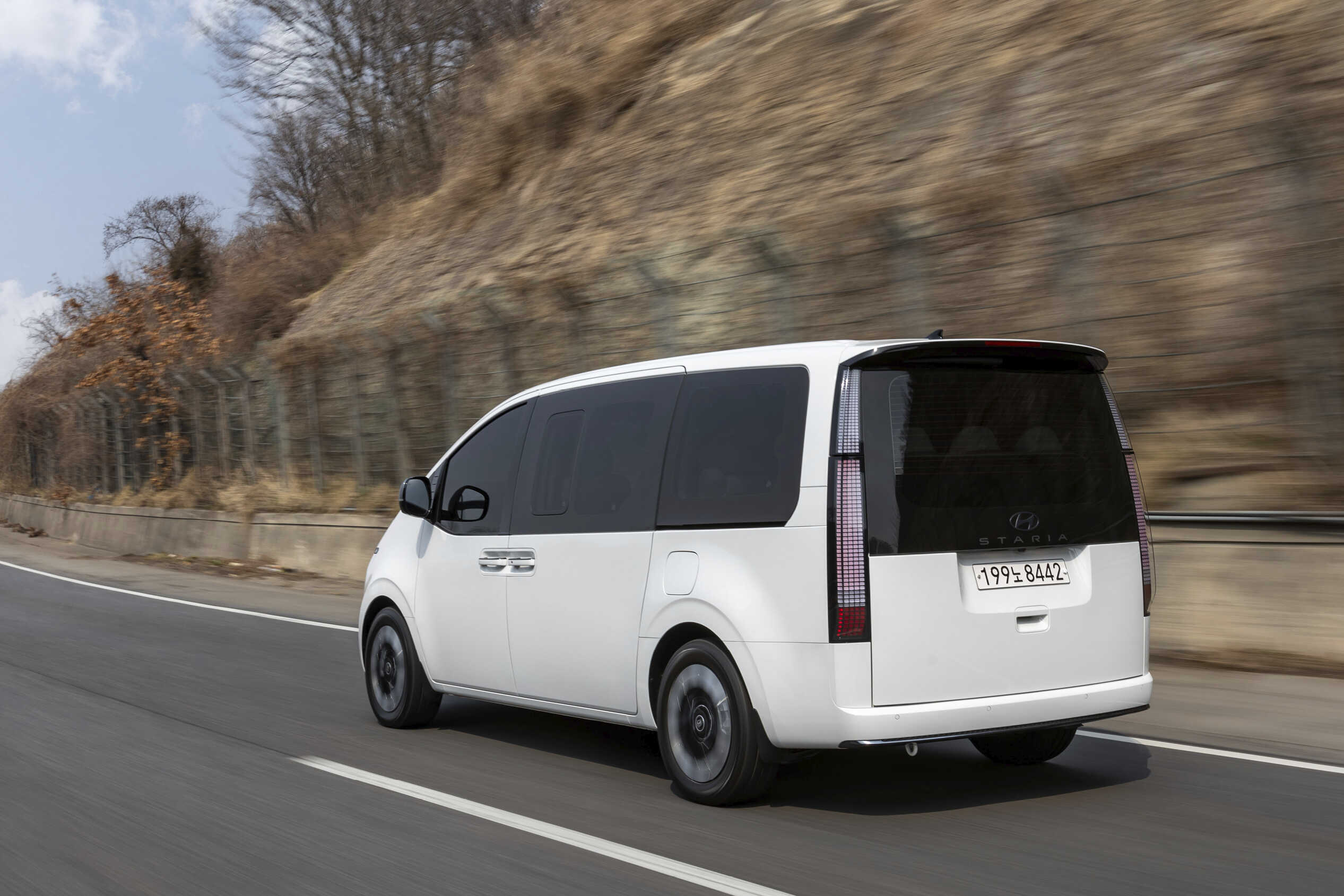 고속도로를 주행하는 흰색 스타리아의 후측면 모습