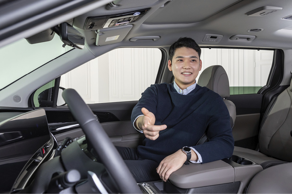 조수석에 앉은 남성이 운전석을 향해 팔을 뻗은 모습