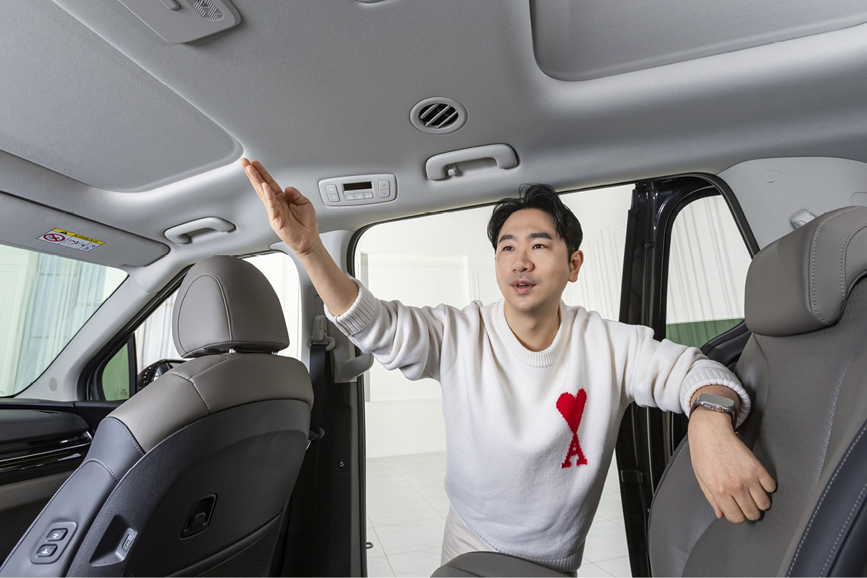 남성이 슬라이딩 도어 바깥에서 실내로 상반신을 넣은 채 오른손을 뻗어 대화하는 모습