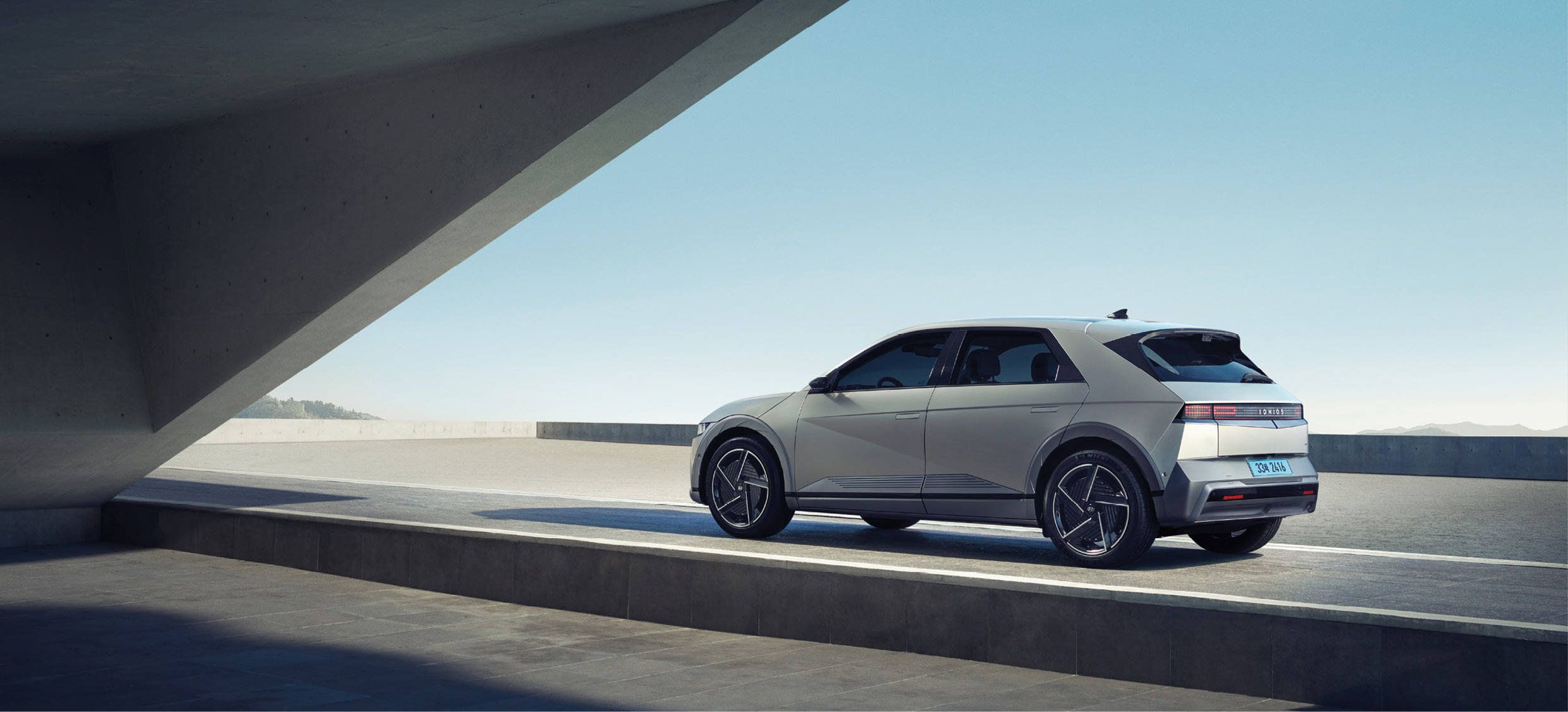 The rear view of the IONIQ 5 in front of a beautiful building.