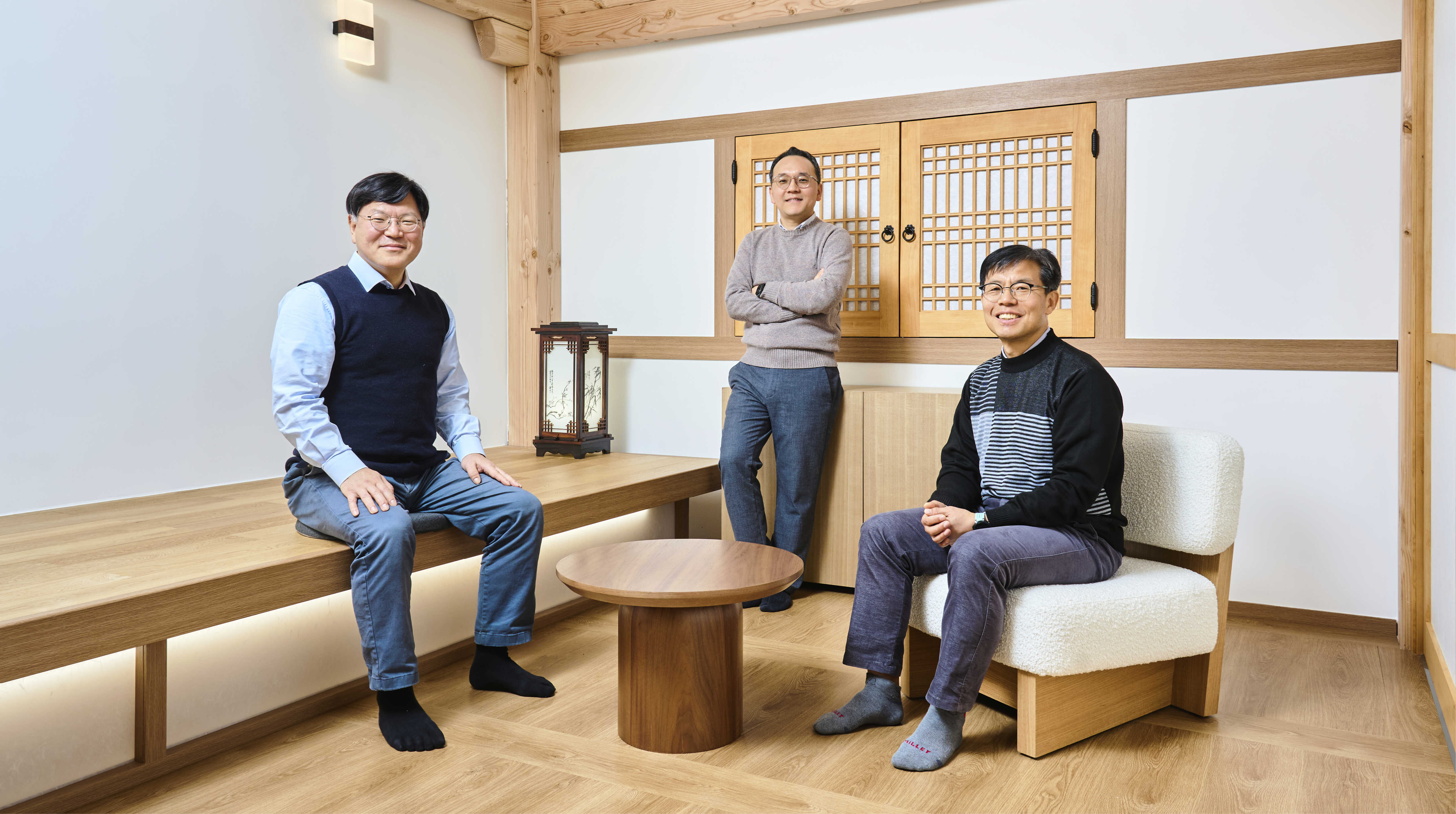 남성 셋이 한옥 실내에서 포즈를 취한 모습