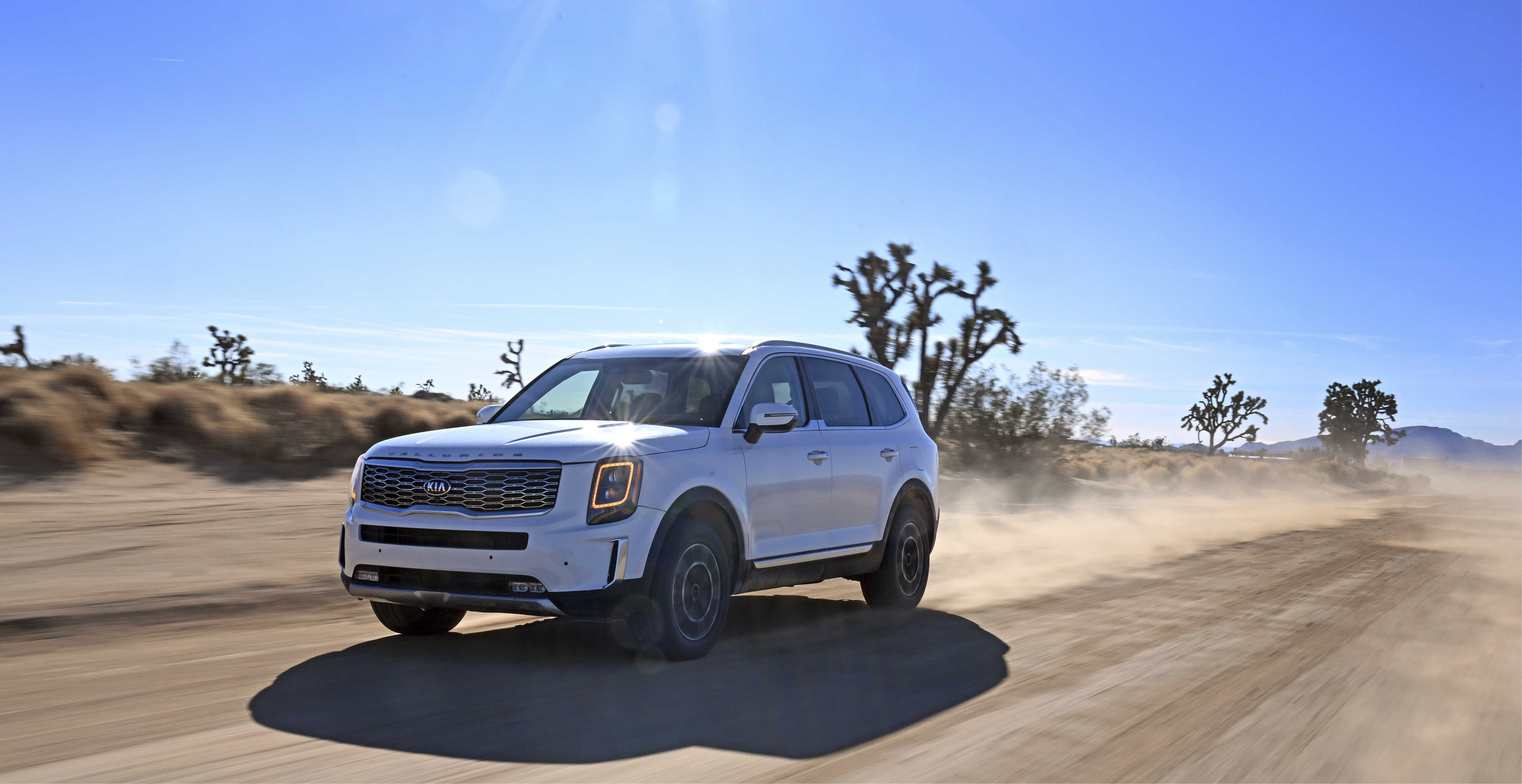 서부 사막을 주행하는 흰색 SUV의 전측면 모습