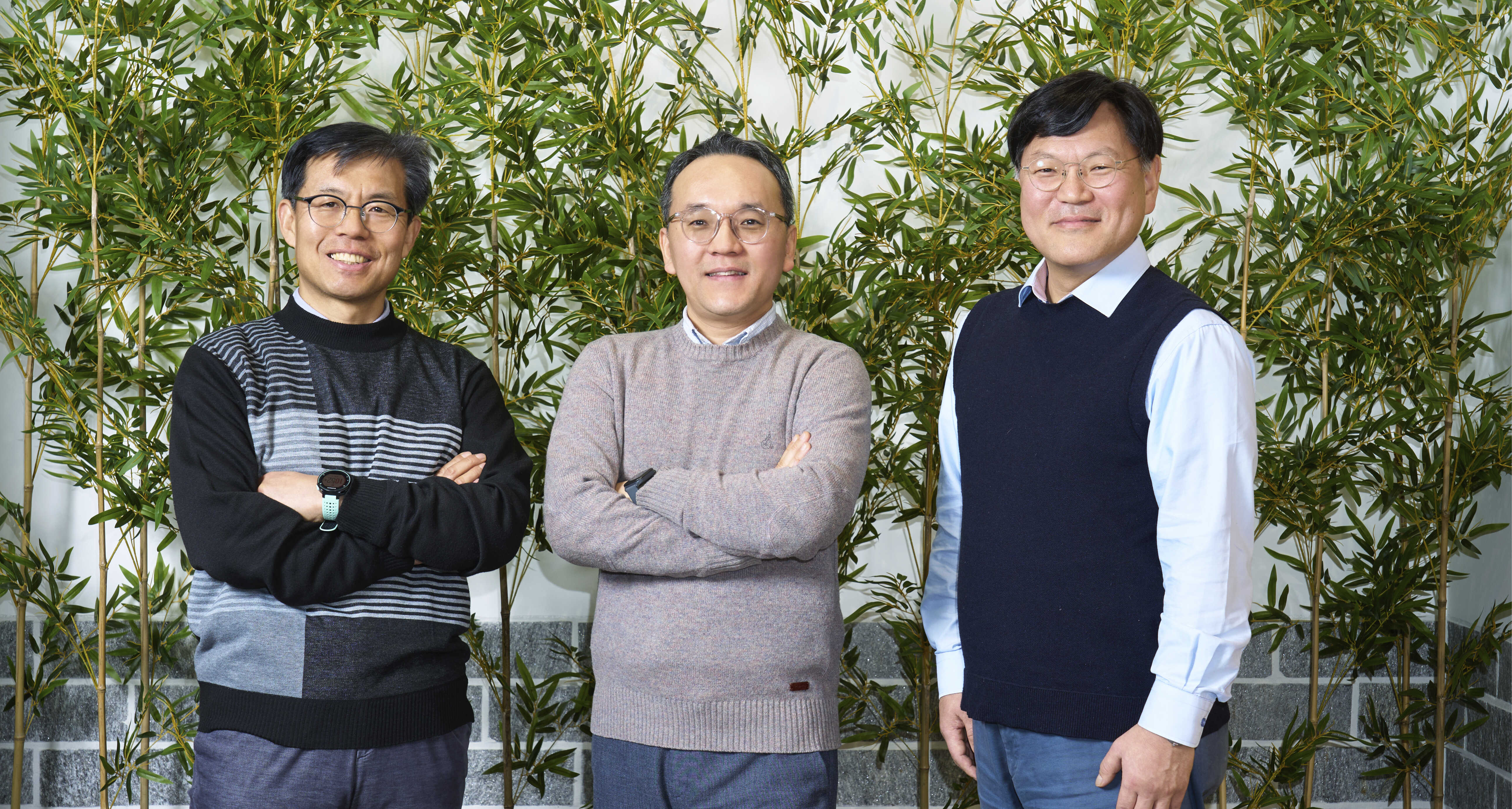 대나무를 배경으로 남성 세 명이 팔짱을 낀채 정면을 응시하는 모습