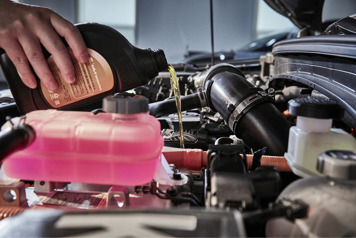 보닛을 열고 오일류를 넣고 있는 모습