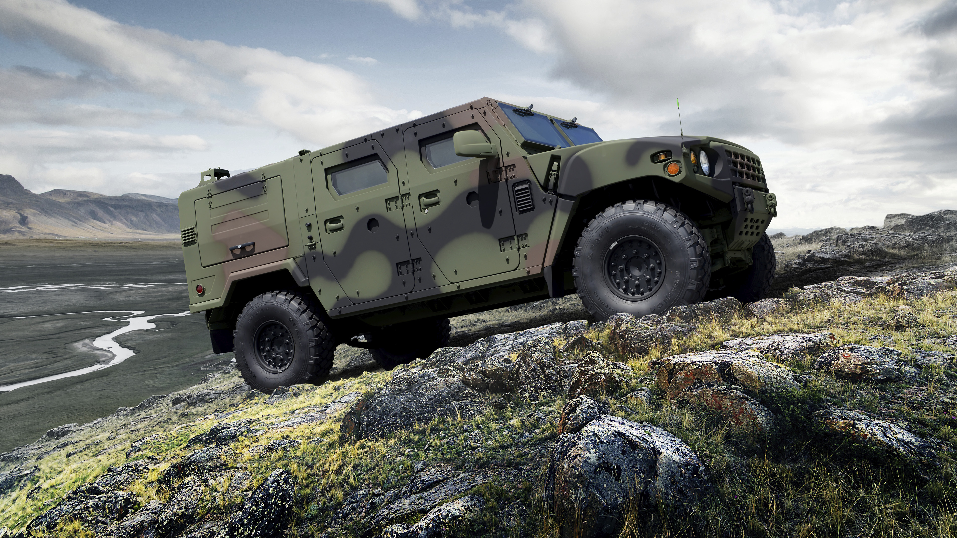 the side of a military vehicle stopping on a hill