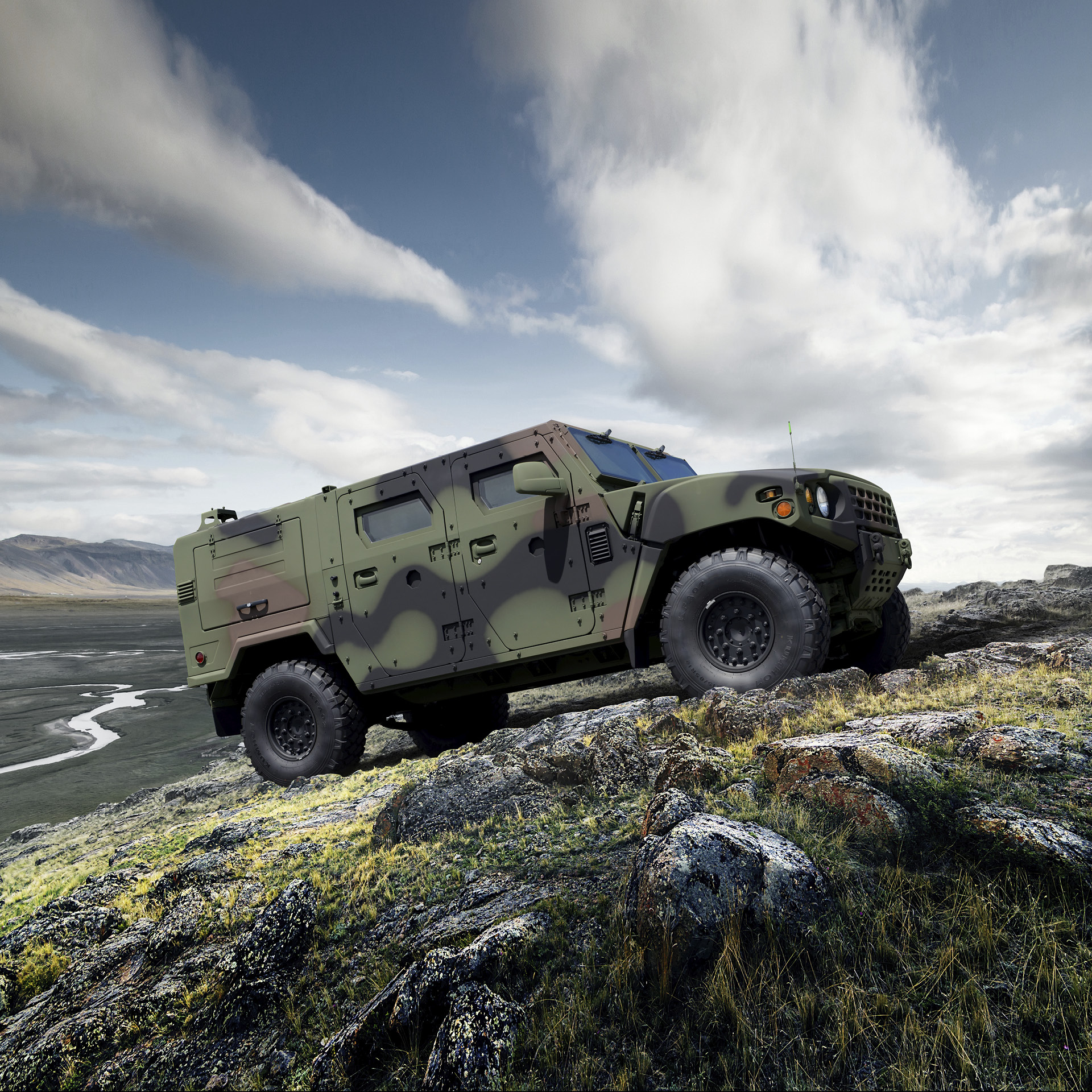 the side of a military vehicle stopping on a hill
