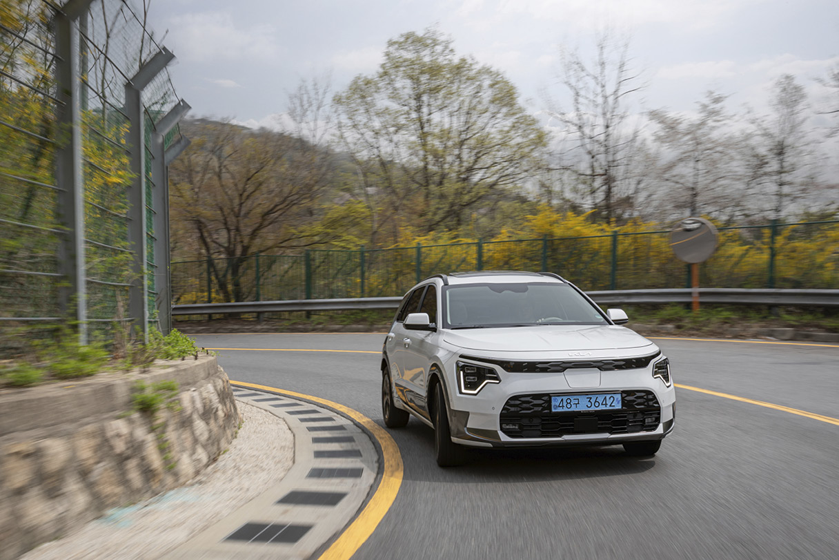 개나리가 핀 코너를 달리고 있는 니로 EV의 전면