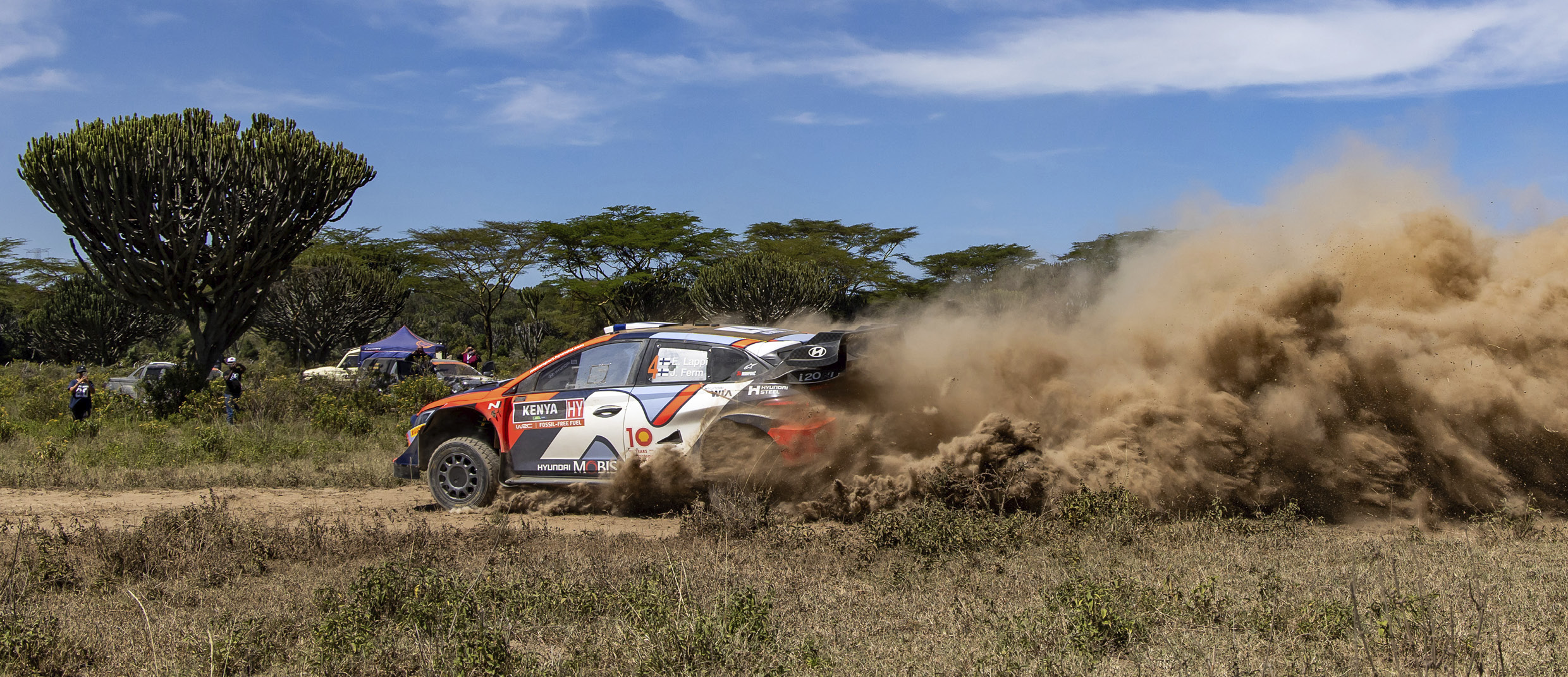 the sight of a rally car running through a rough road
