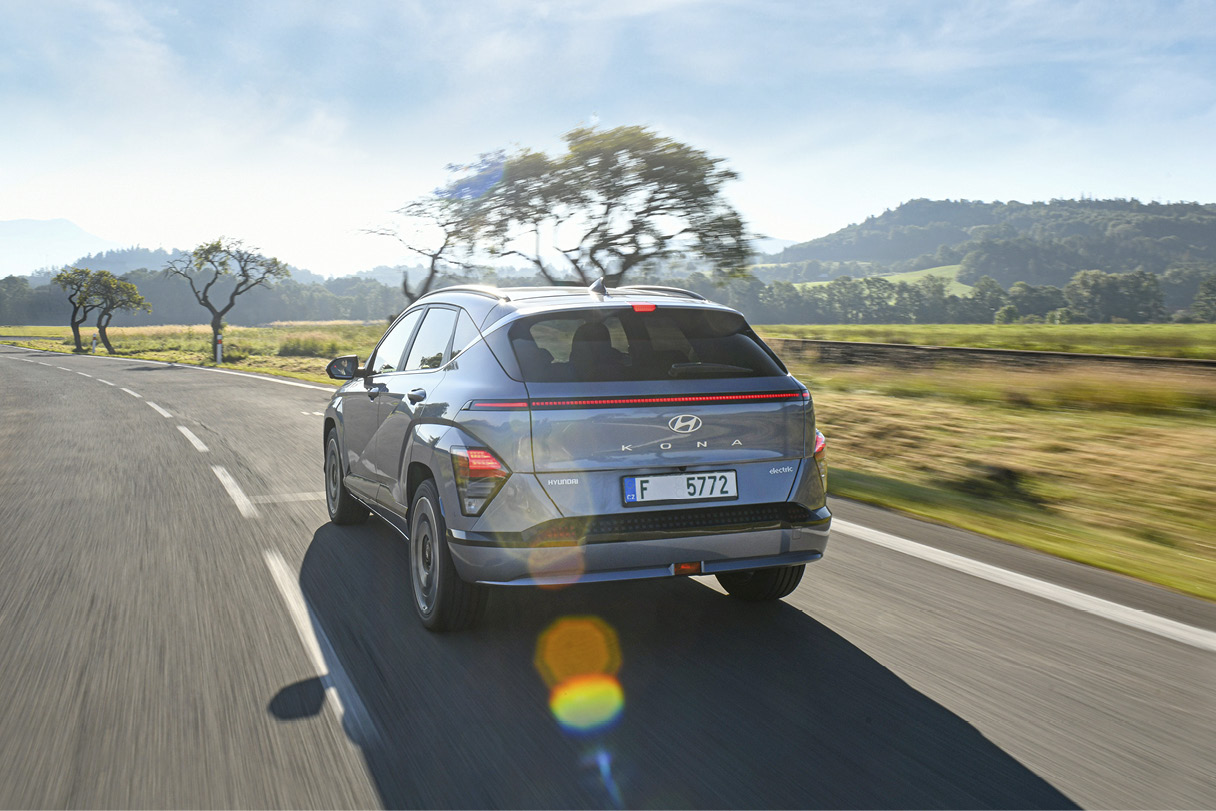 코나 일렉트릭이 유럽 교외를 주행하는 후측면 모습