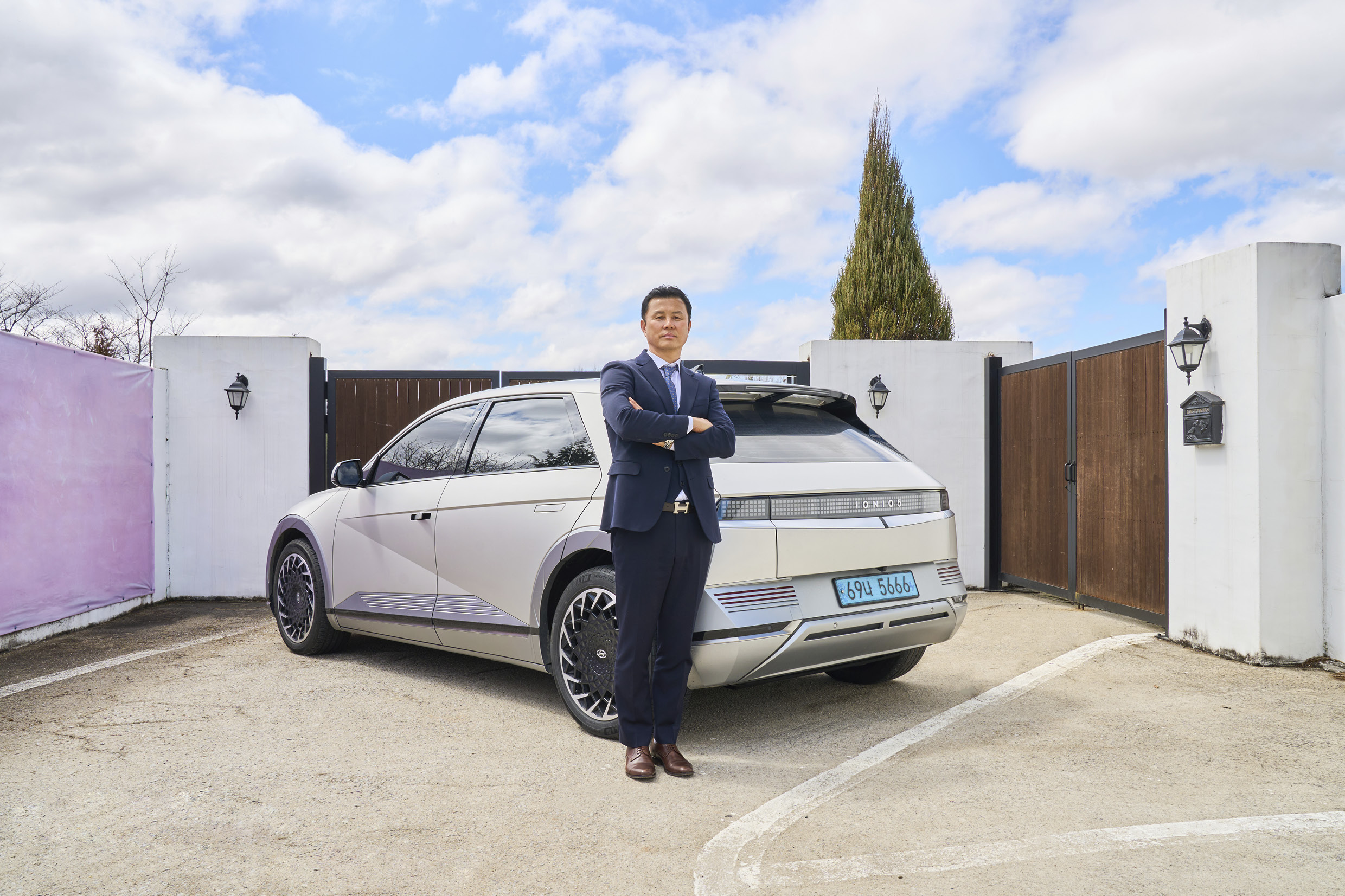 아이오닉 5에 기대어 팔짱을 끼고 있는 권태일 카마스터