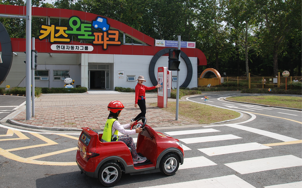 안내원의 안내에 따라 올바른 운전 방법을 교육받고 있는 어린이