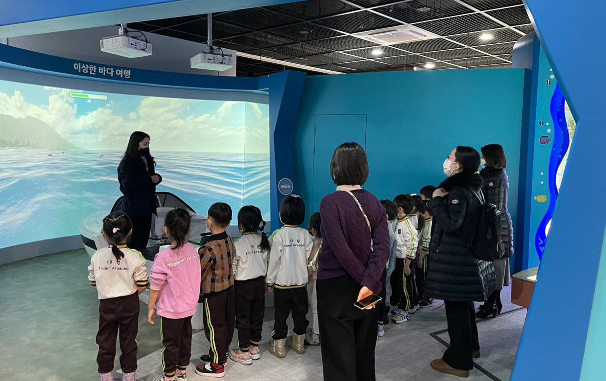 안내원의 설명을 듣고 있는 어린이들과 부모님들