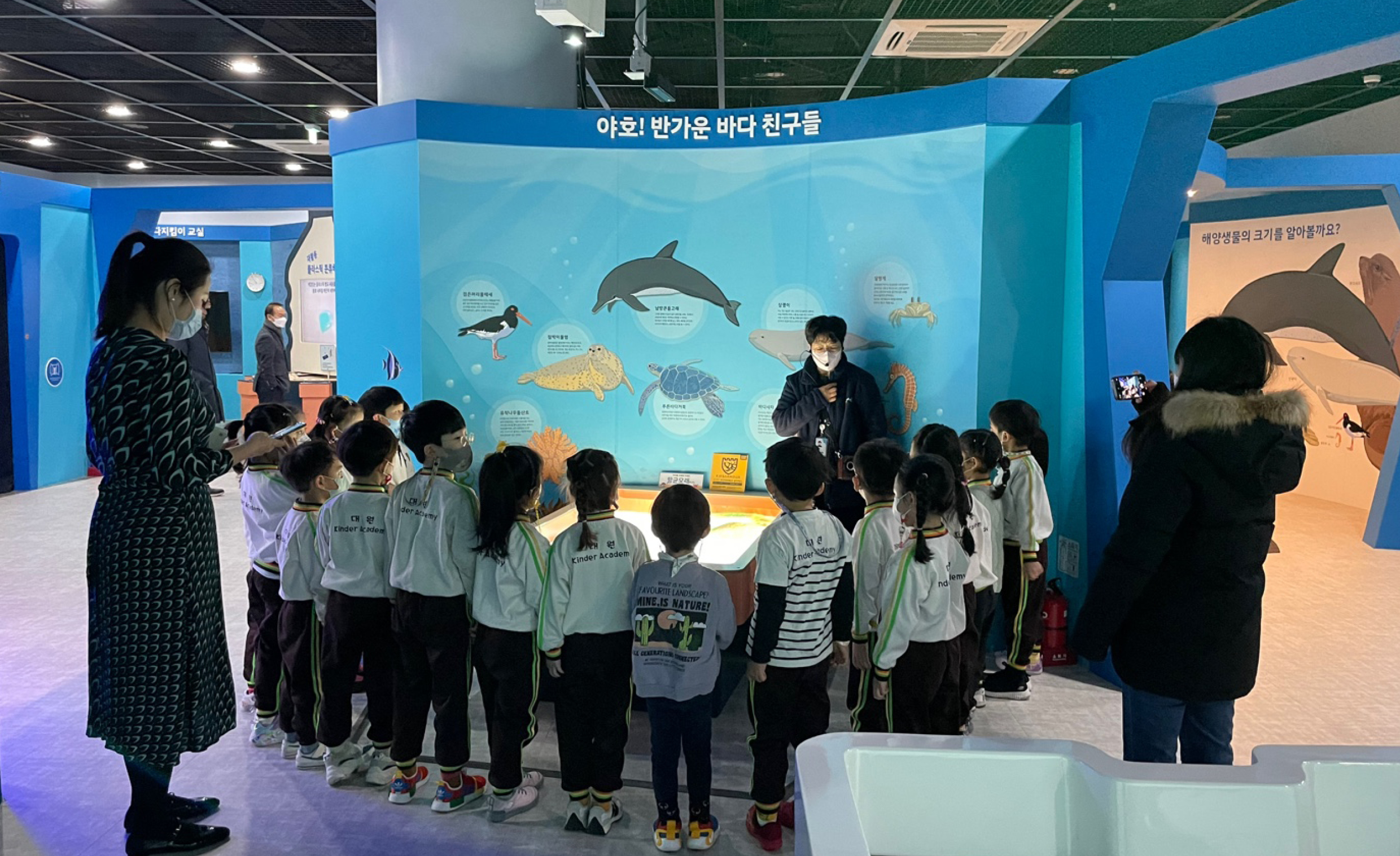 안내원의 설명을 듣고 있는 어린이들과 부모님들