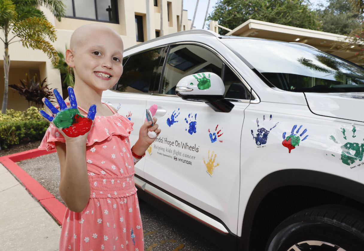 차량에 손바닥 도장을 찍고 환하게 웃는 아이
