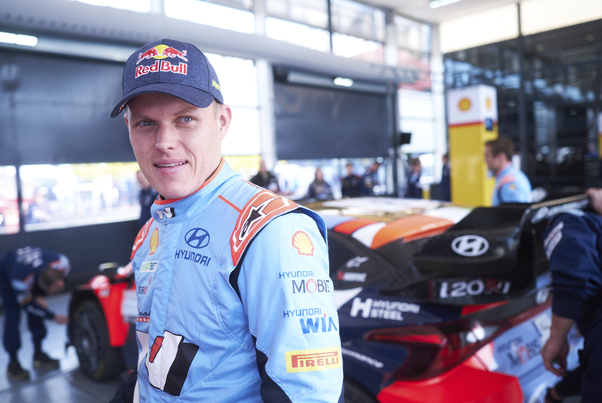 Ott tanak is posing in front of Rally cars