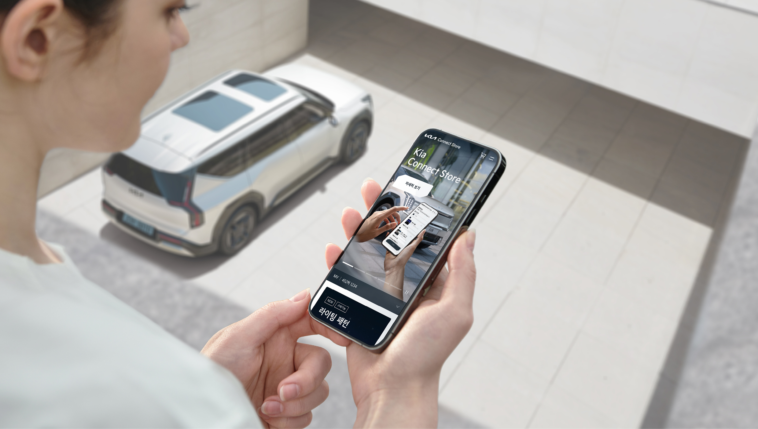 여성이 자동차를 내려다보면서 손에 든 핸드폰을 함께 확인하는 모습