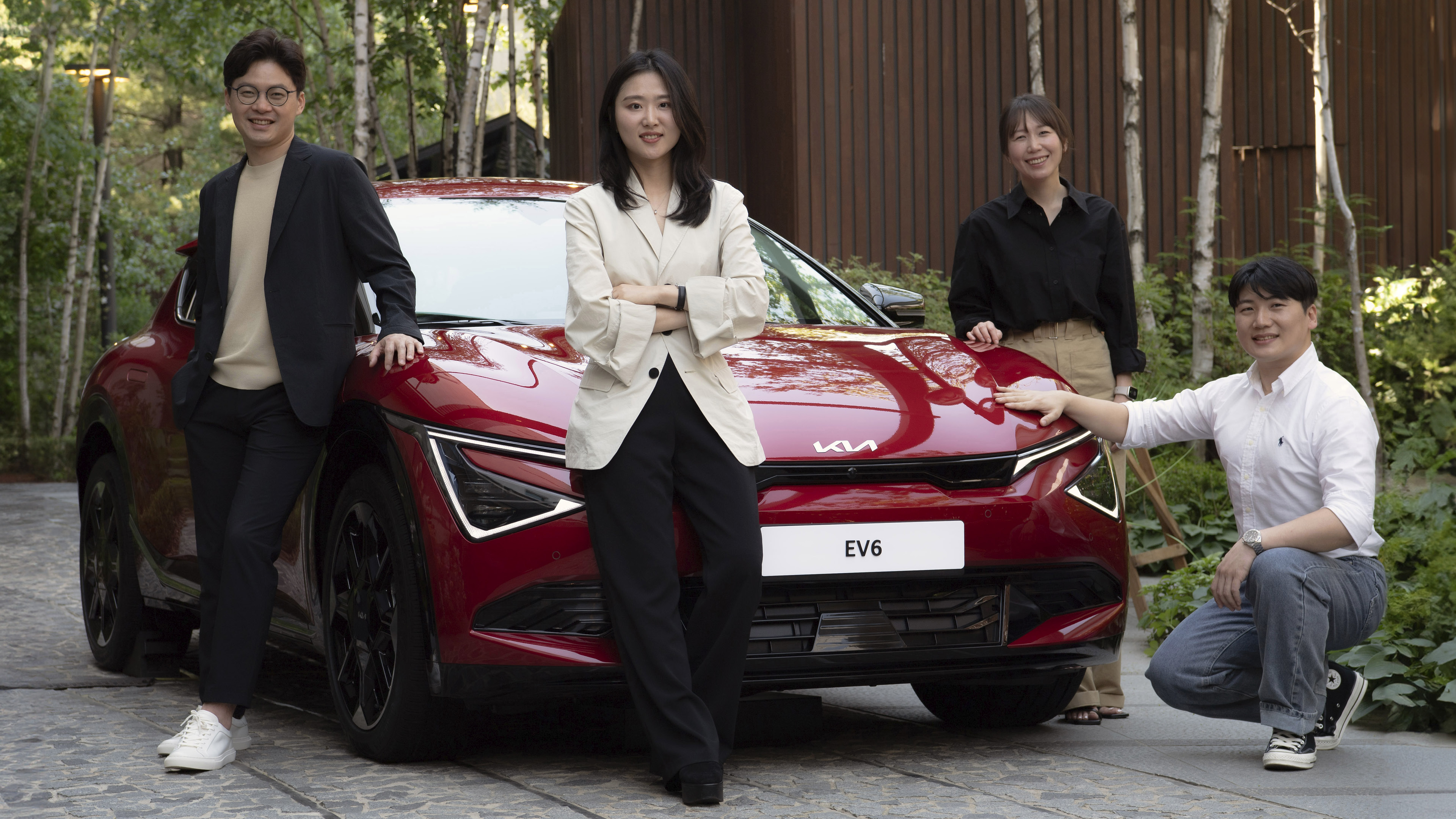 차량 앞에 서있는 디자이너들