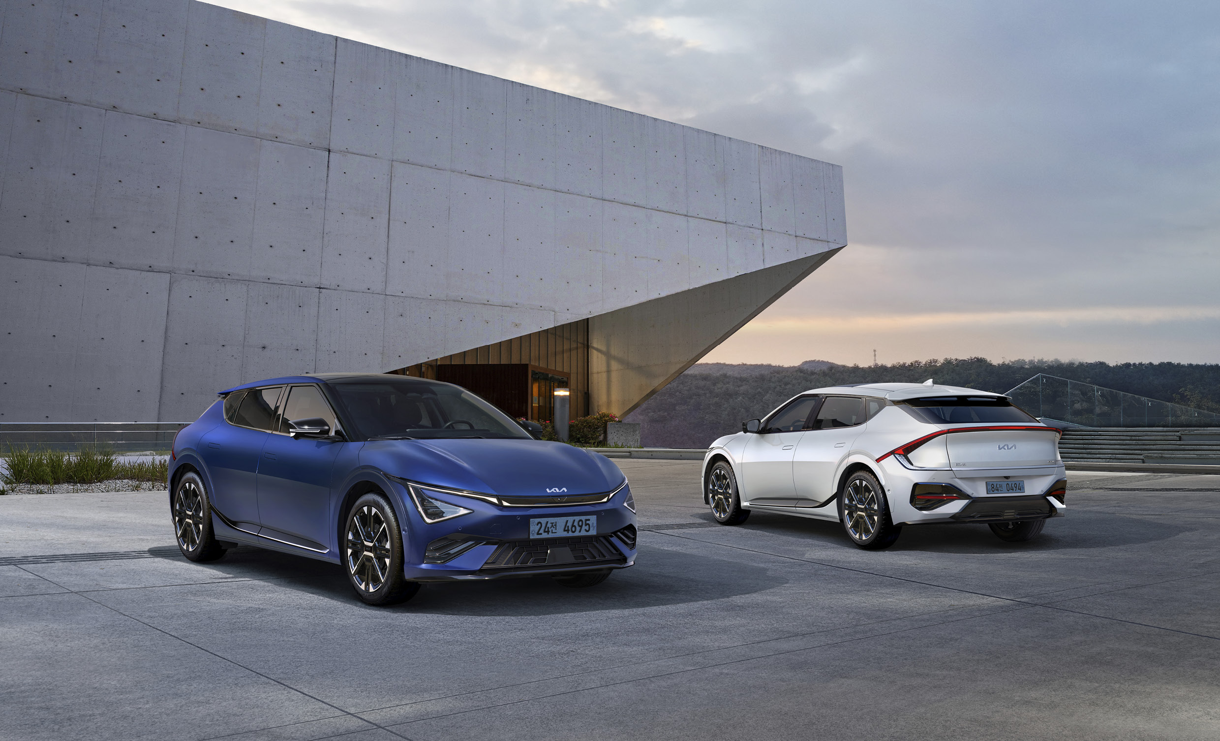 멋스러운 건물 앞에서 서로 반대 방향을 향해 서있는 차량 두 대