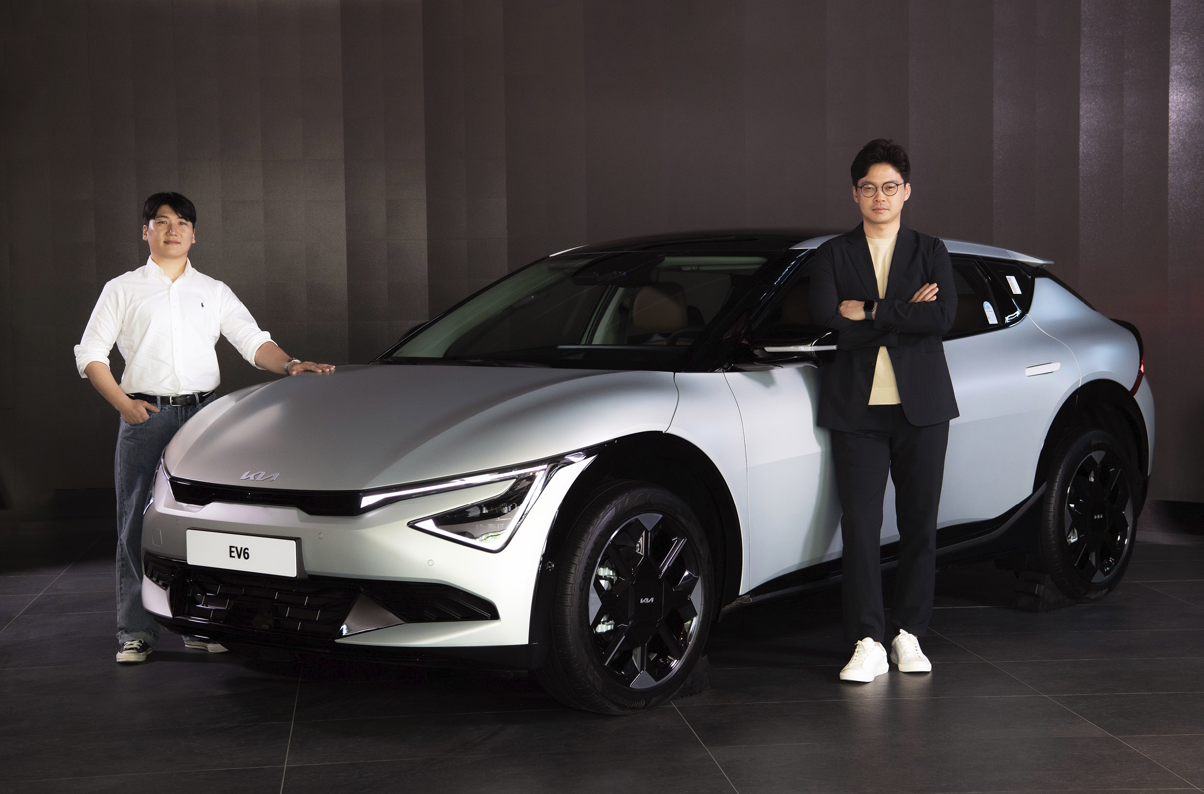 차량 양 옆에 서있는 두 명의 디자이너