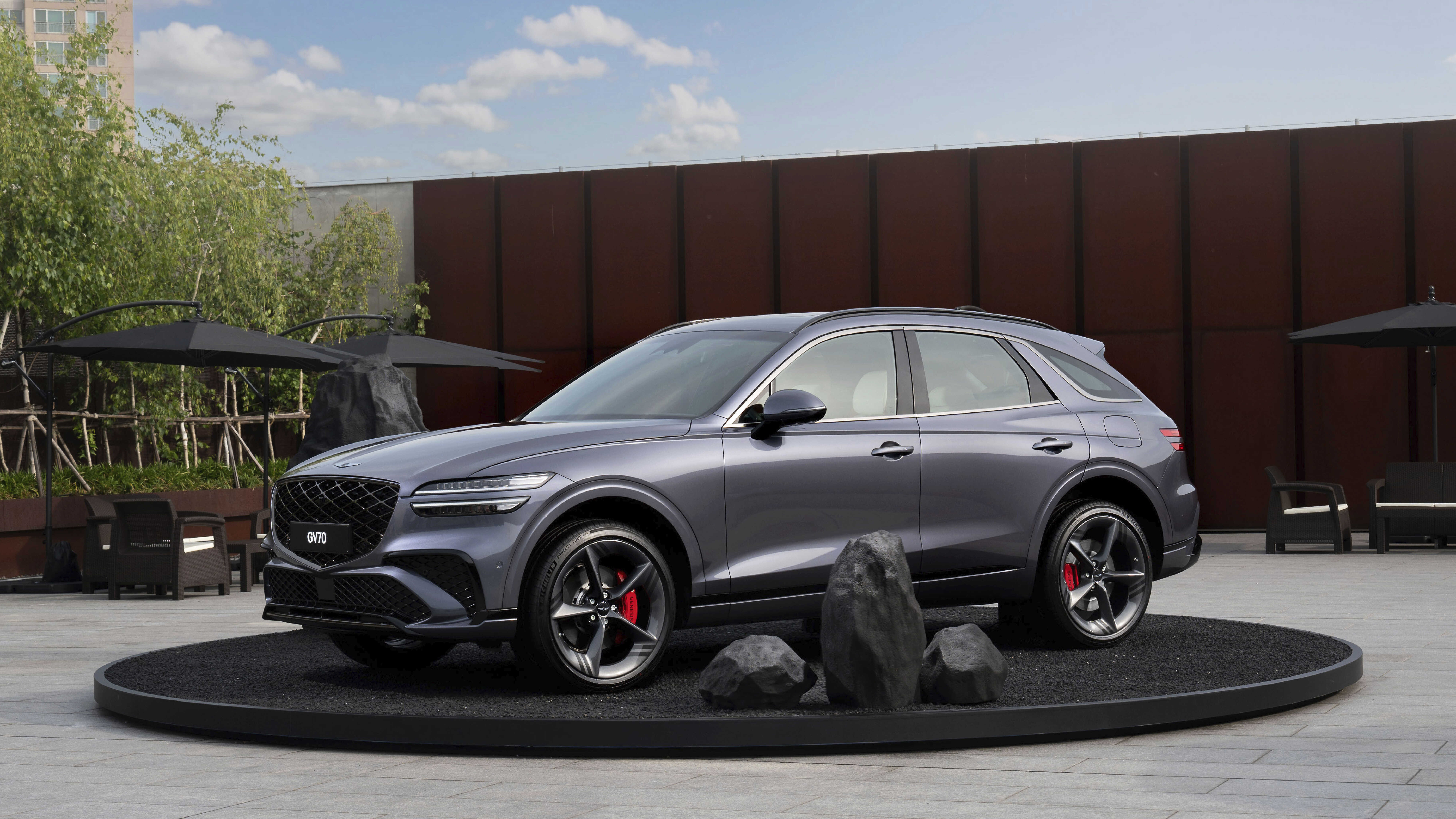 야외 무대에 전시된 그레이 컬러 중형 SUV 전측면 모습