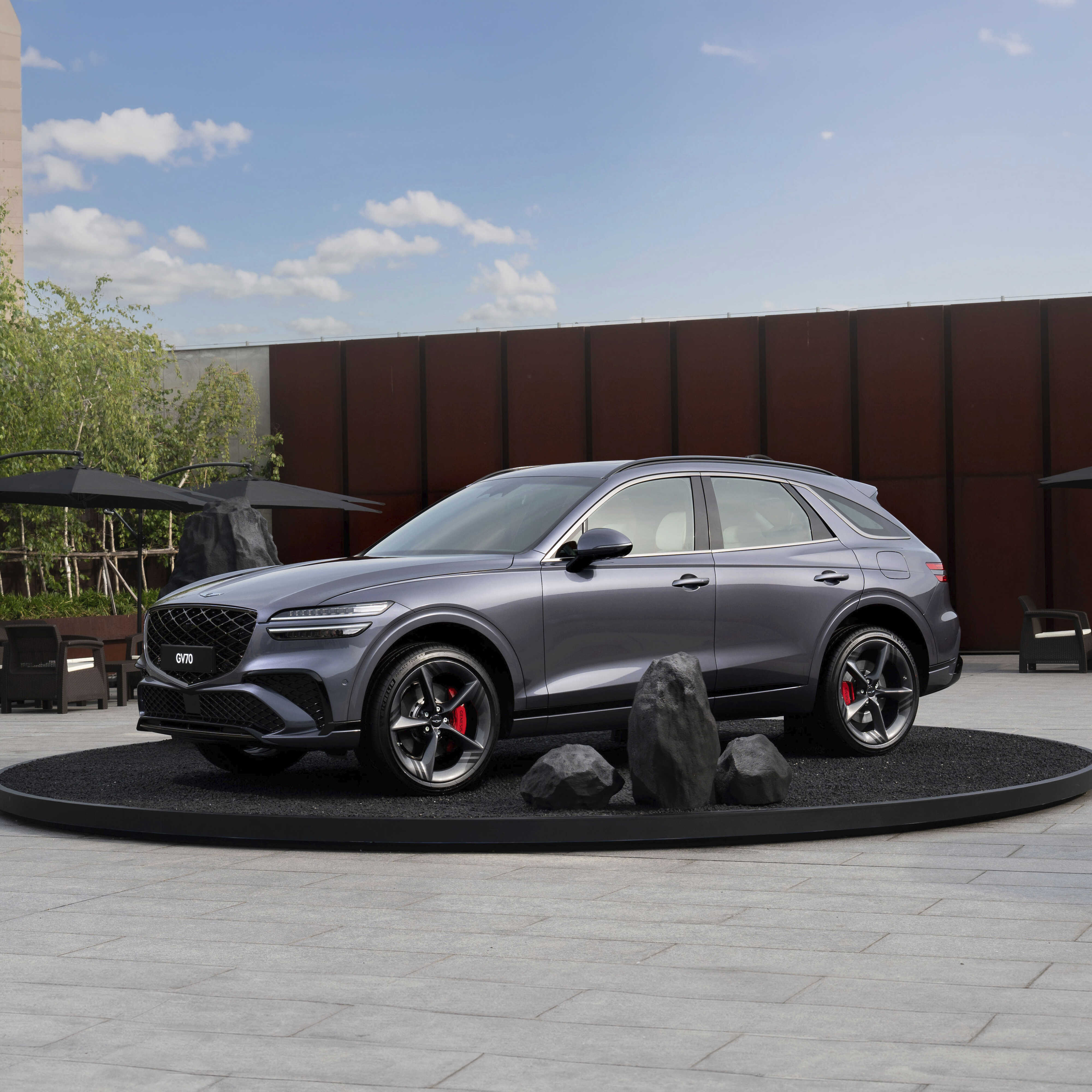 야외 무대에 전시된 그레이 컬러 중형 SUV 전측면 모습