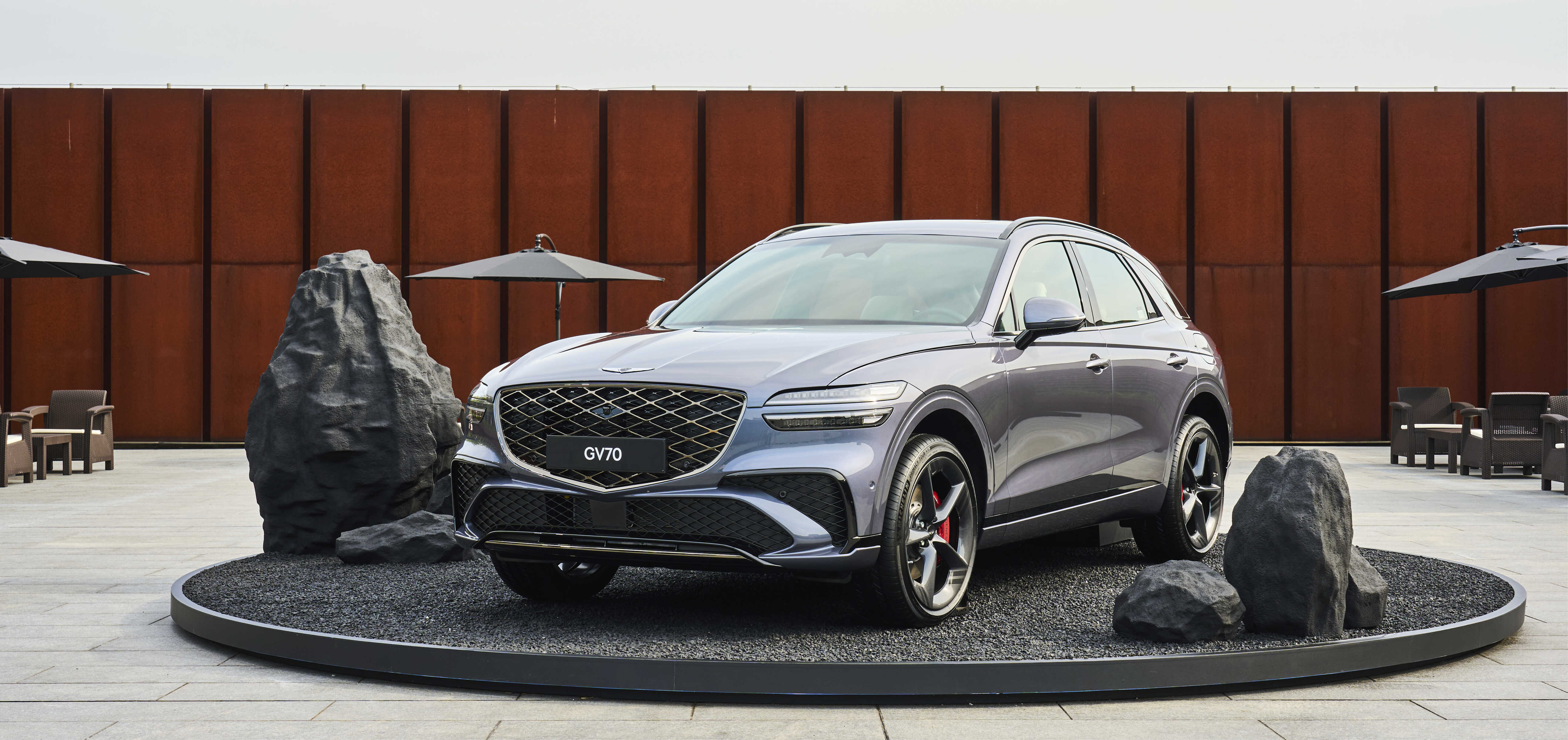 야외 무대에 전시된 그레이 컬러 중형 SUV 전측면 모습