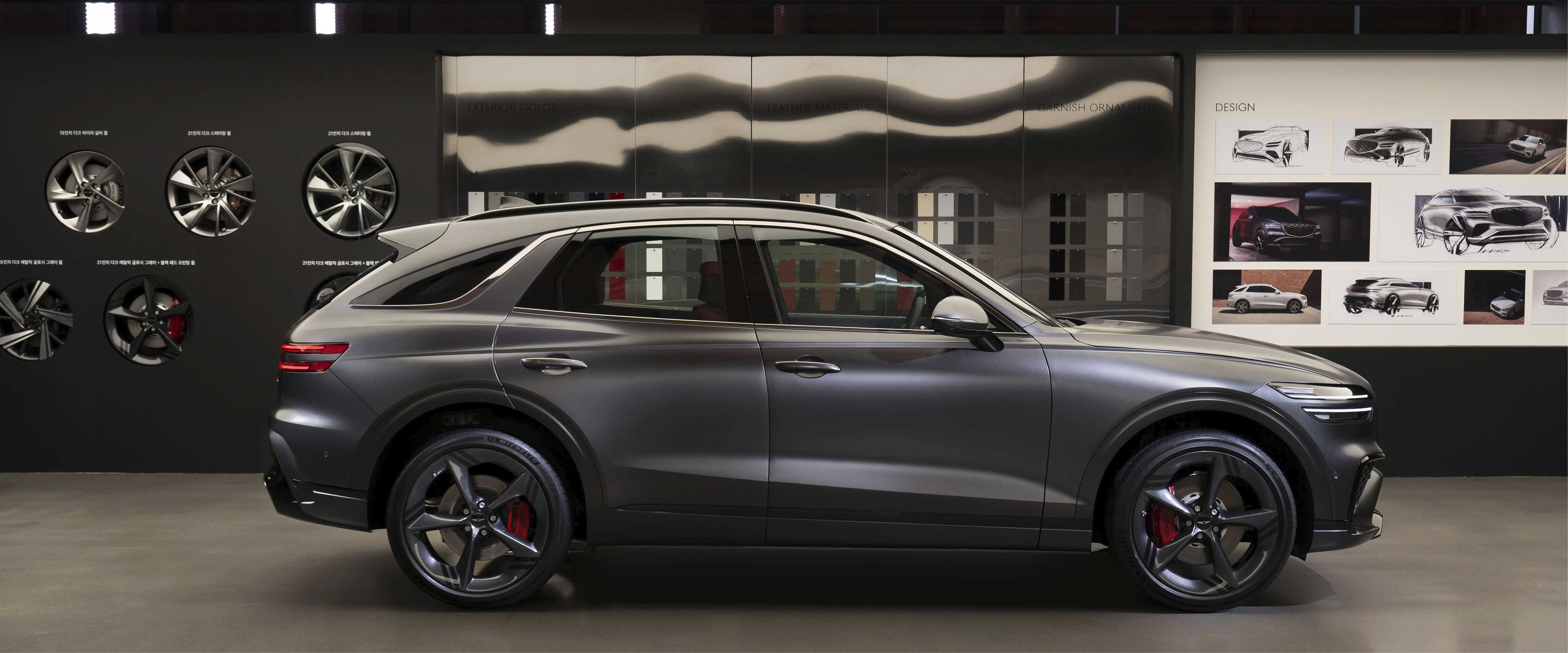 그레이 컬러 중형 SUV가 실내 전시장에 위치한 정측면 모습