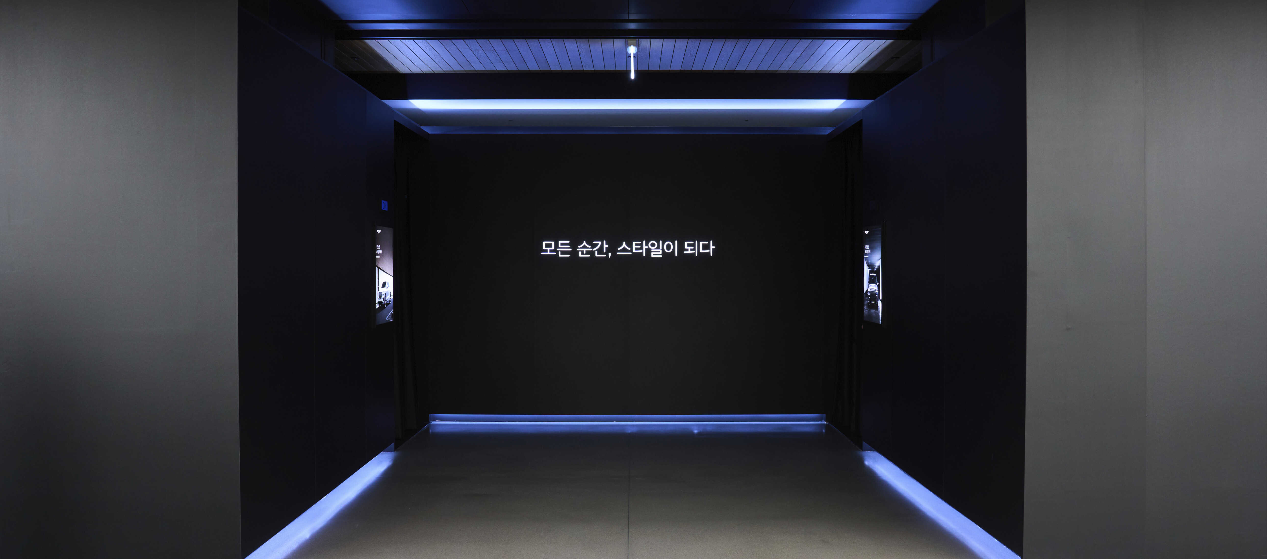 실내 전시장 가운데 간접 조명이 설치된 두 개의 입구 모습