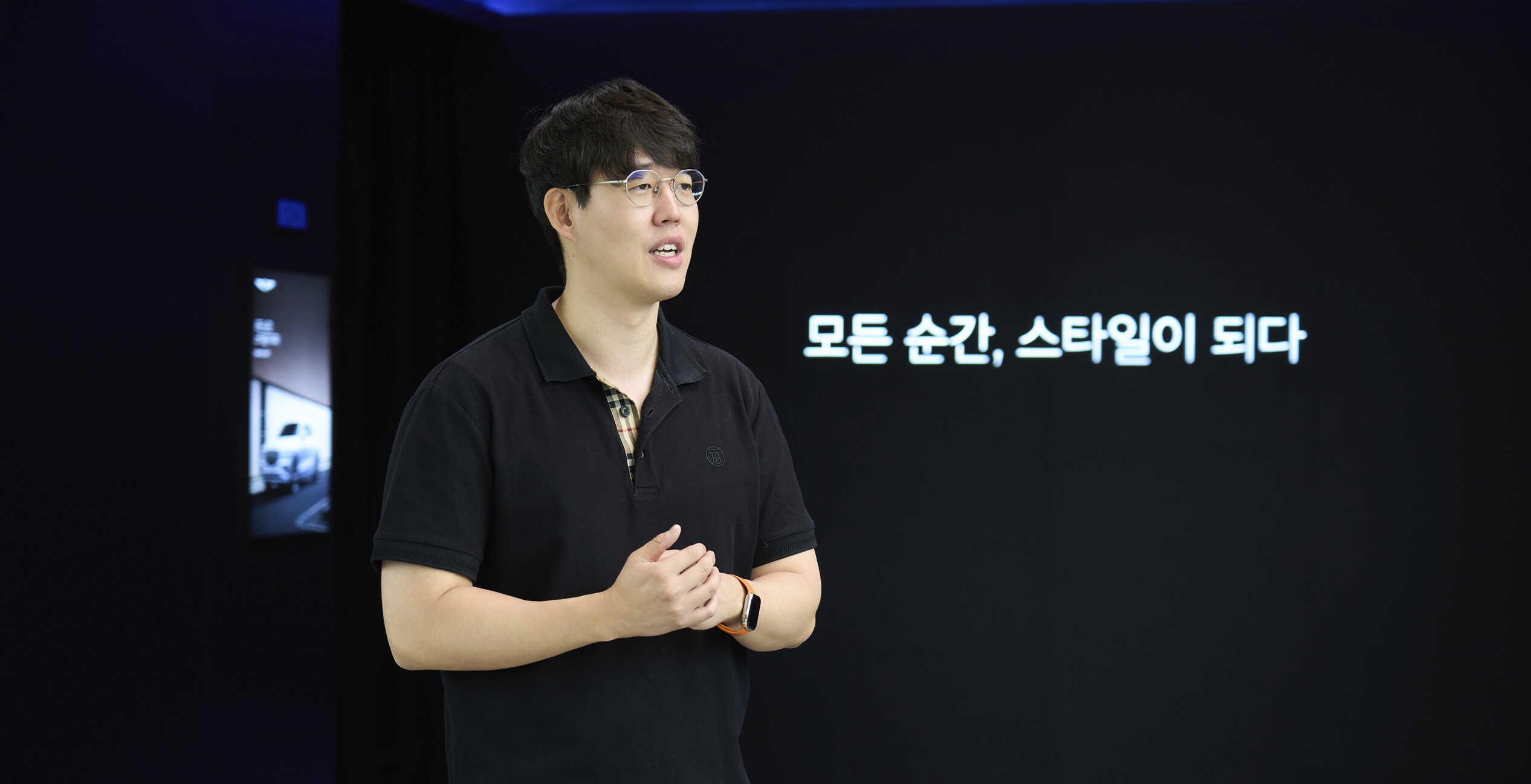 전시장에서 남성이 두 손을 모으고 이야기하는 모습