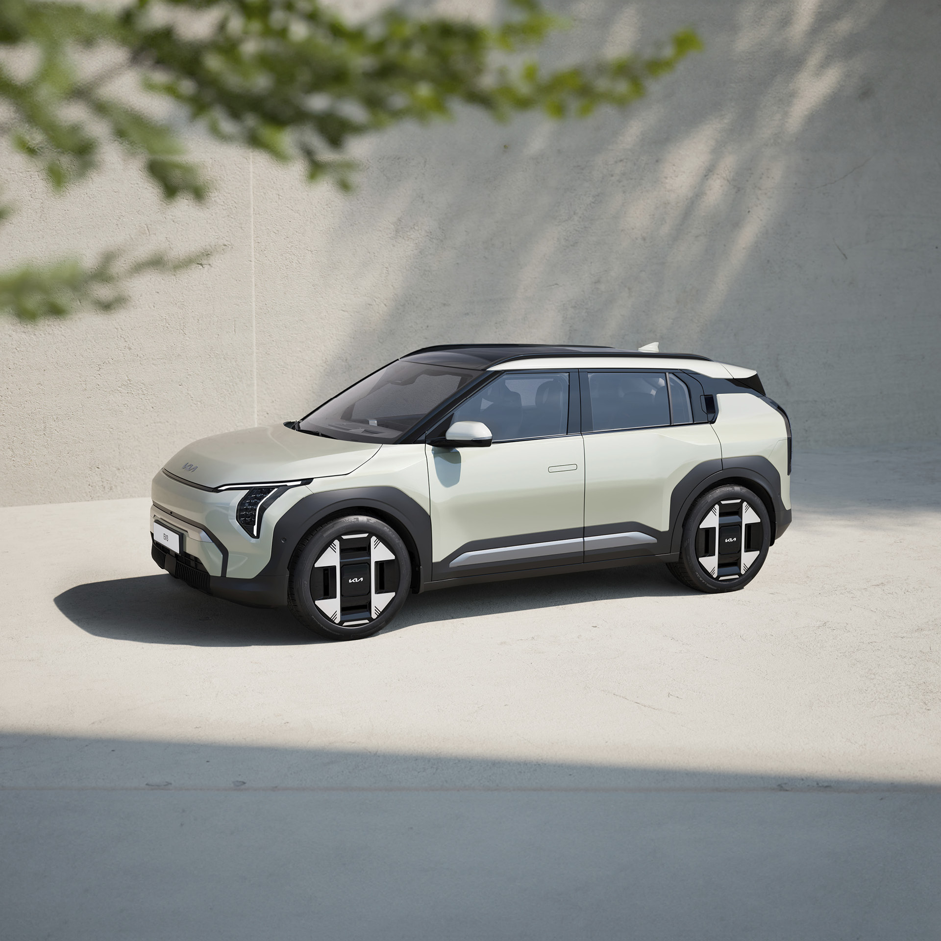 회색 건물과 바닥에 주차된 소형 SUV 전측면 모습