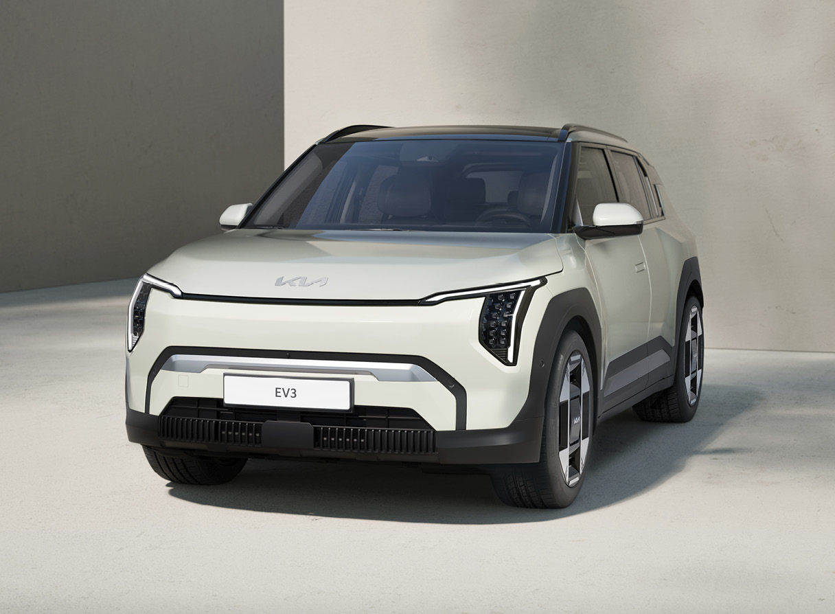 회색 건물과 바닥에 주차된 흰색 소형 SUV 전측면 모습