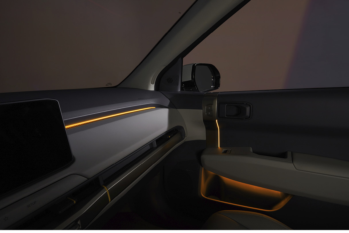 The first row of passenger seats illuminated by lighting in a dark space