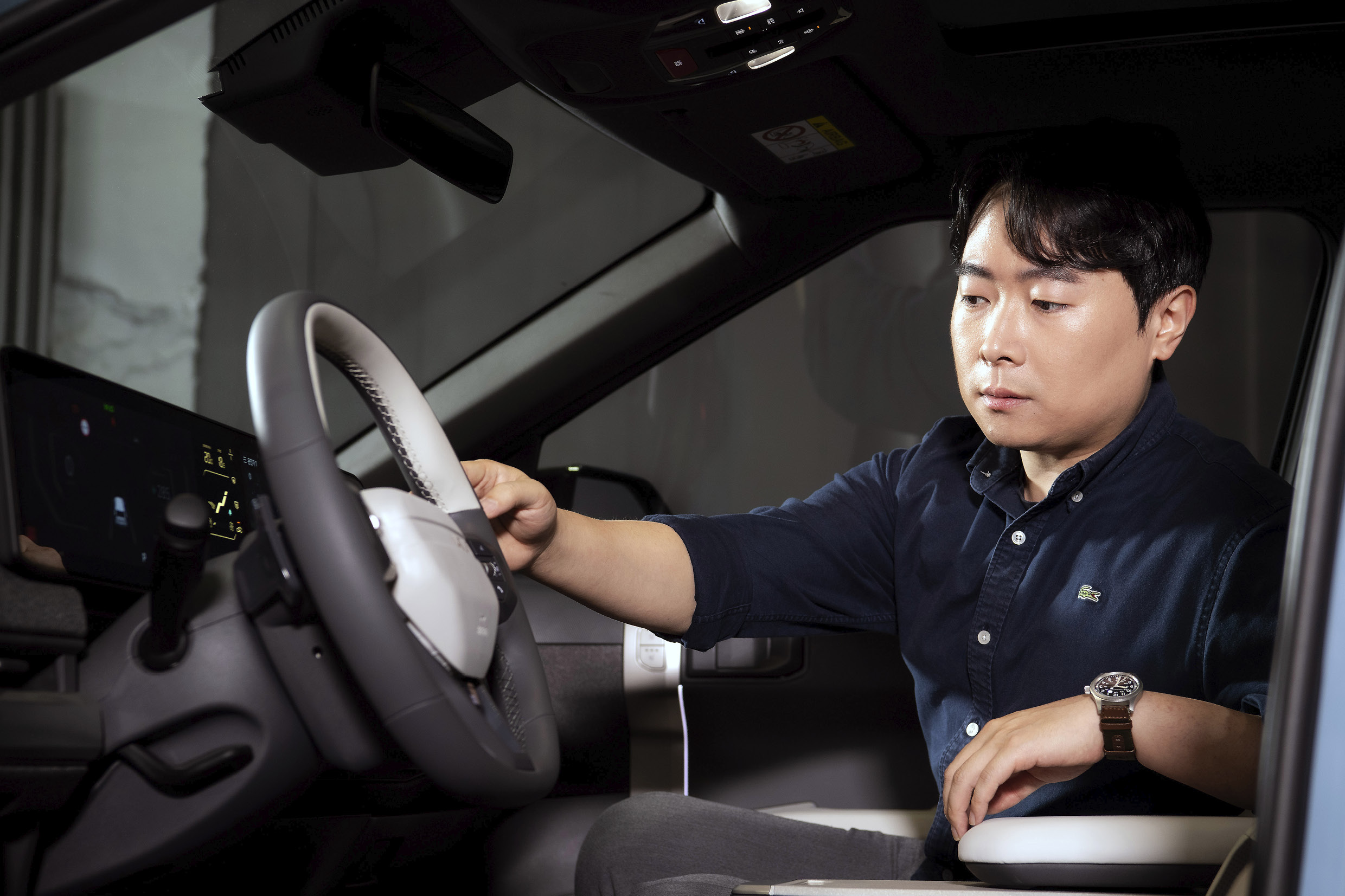 A man in the passenger seat touching the steering wheel