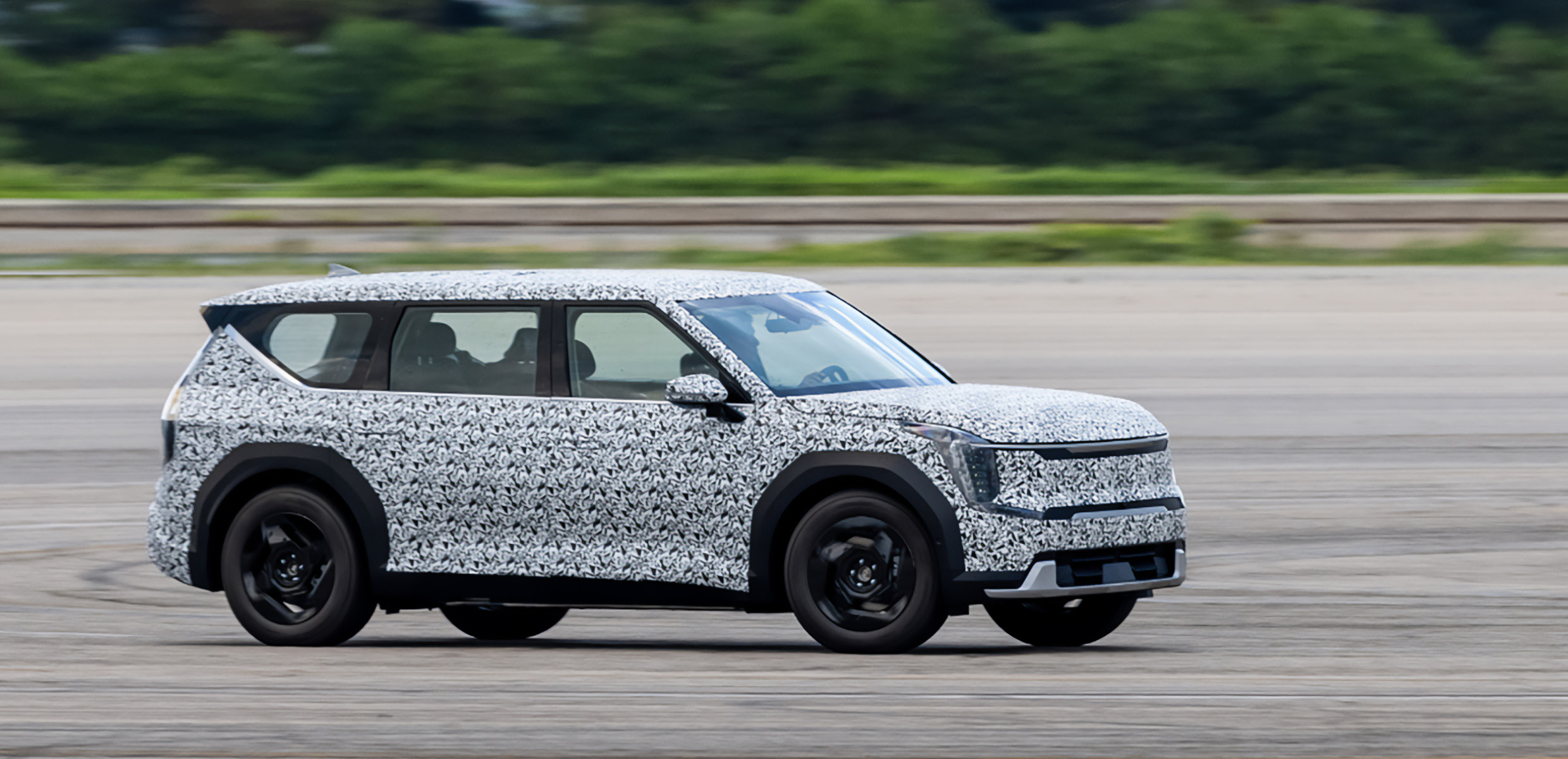 A view of a vehicle driving with a camouflage covering