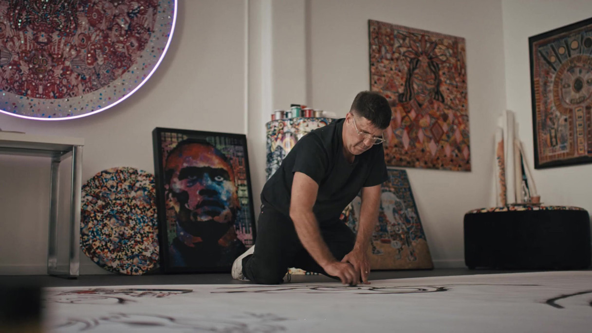The image of a man putting a design on top of a sketch of Tasman