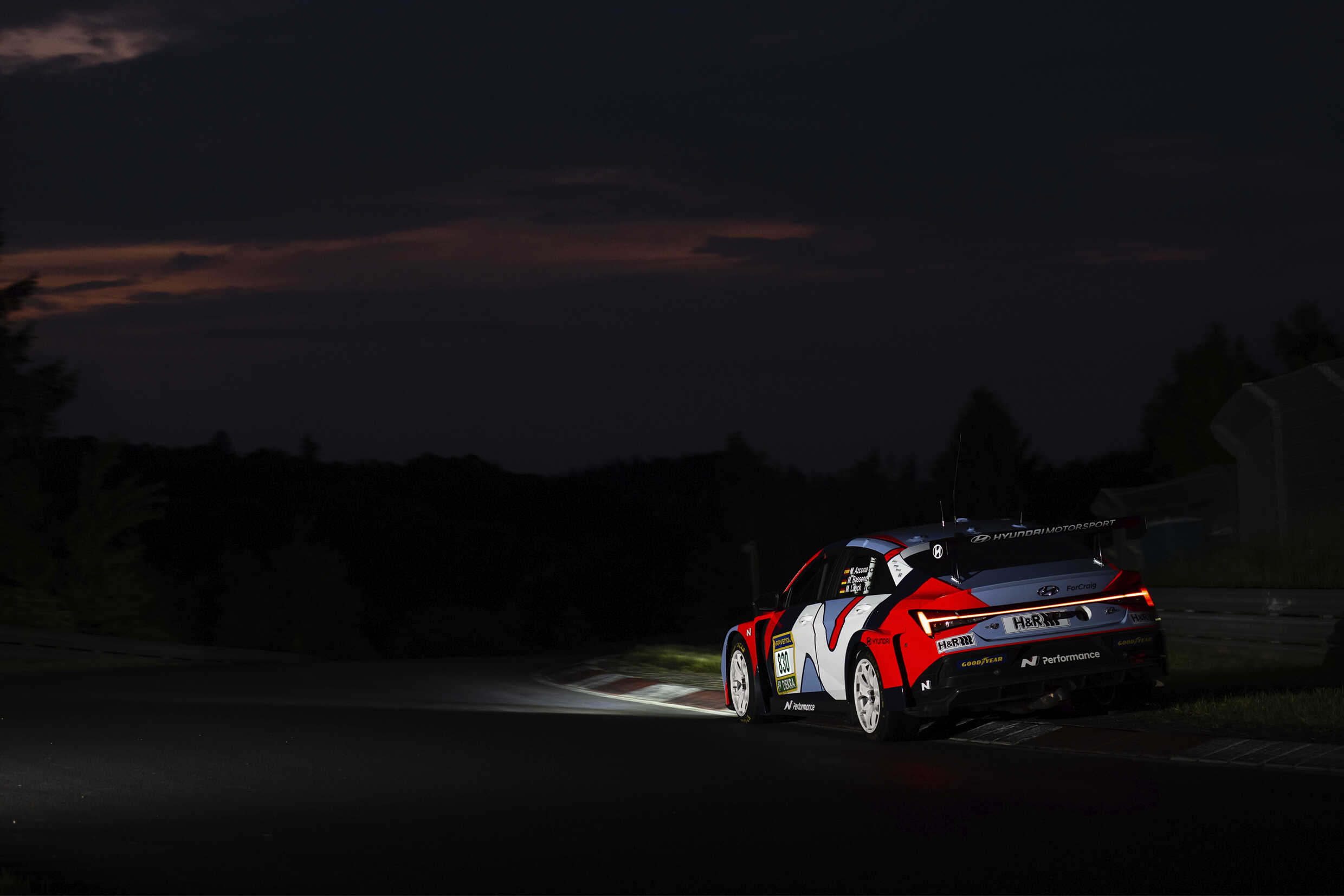 어두운 서킷을 아반떼 N TCR이 주행하는 후측면 모습
